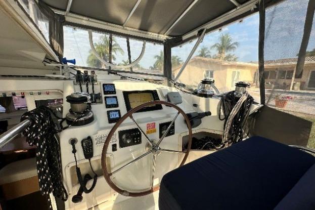 Interior view of 2010 Lagoon 421 yacht cockpit with steering wheel and navigation instruments.