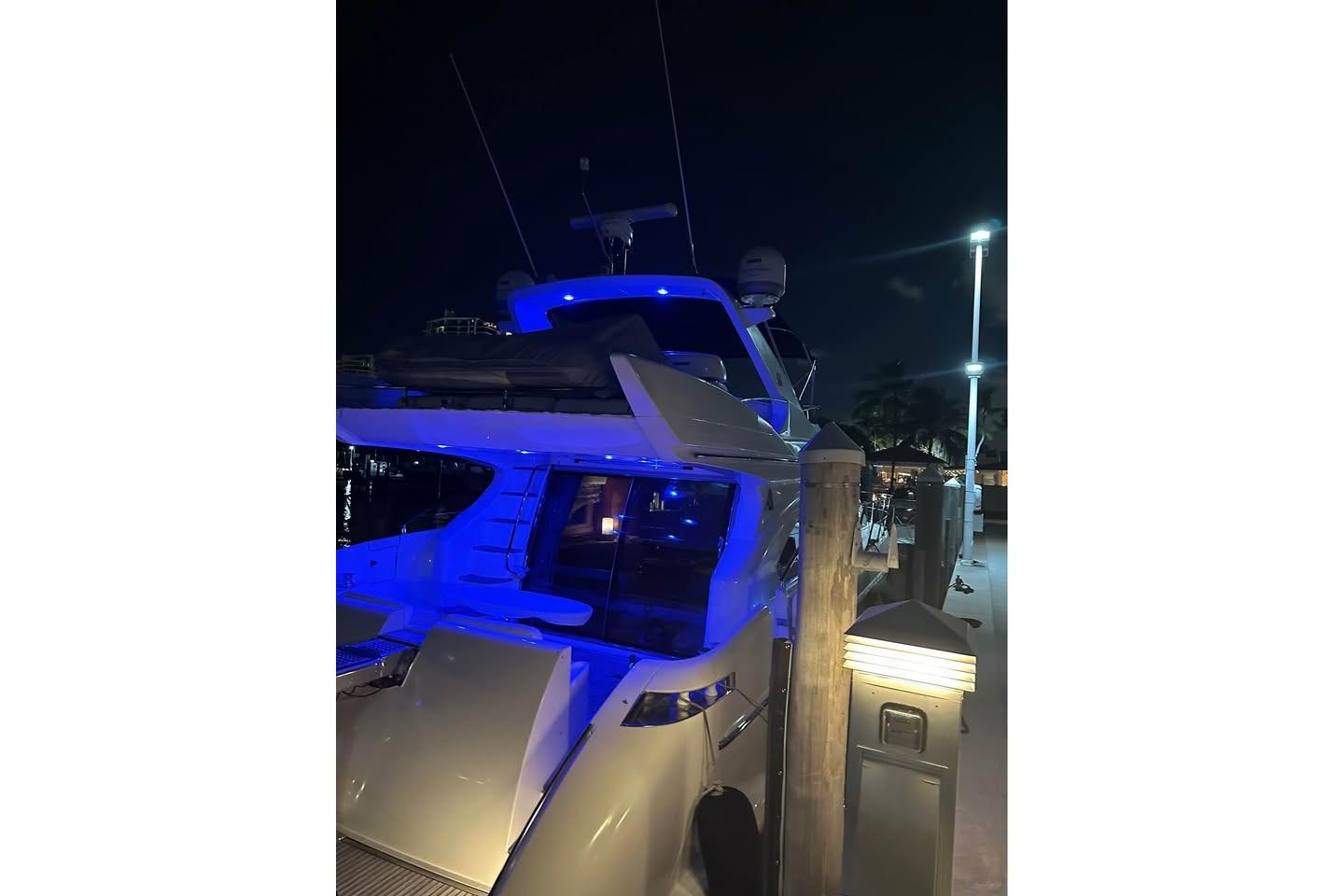 2004 Azimut 55E yacht docked at night with blue lighting.