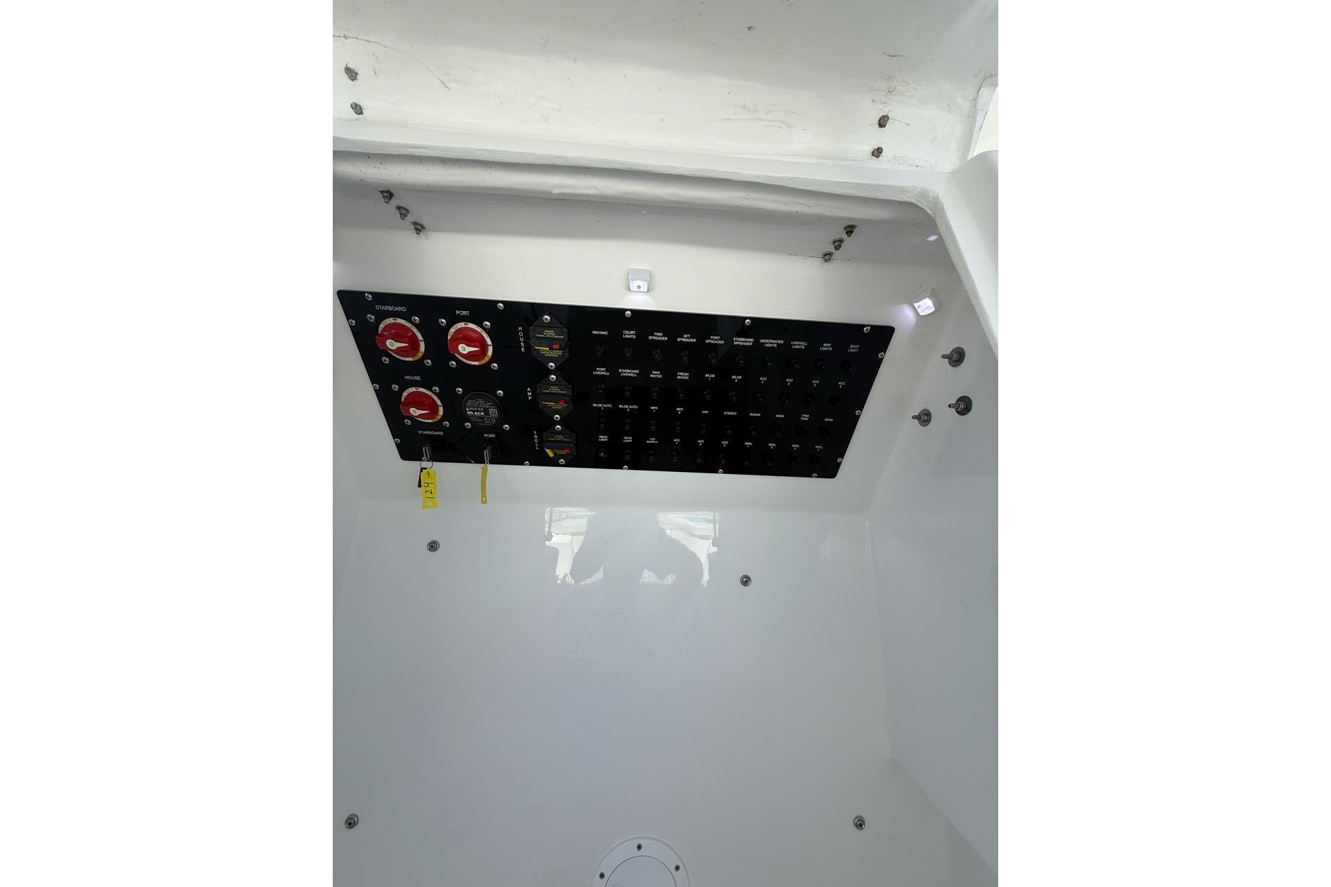 Electrical panel inside 2021 Custom Infusion 34 CC boat, featuring switches and gauges.