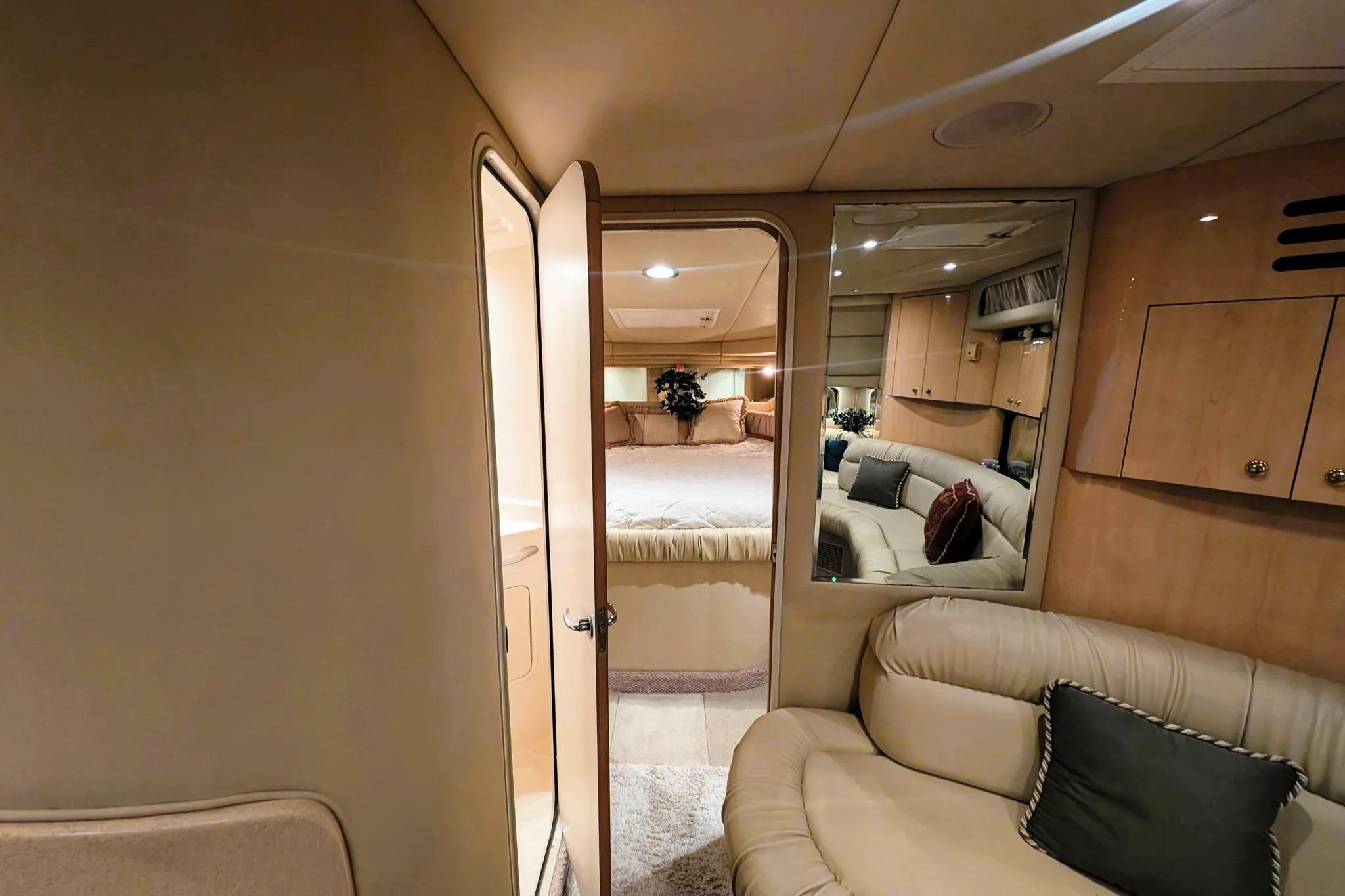 Interior of 2000 Sea Ray 380 Sundancer yacht, featuring cozy seating and elegant cabin design.