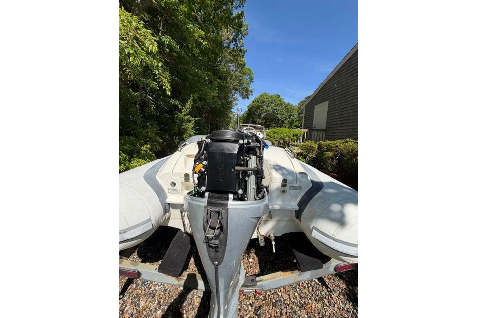 2016 Walker Bay Generation 450 DLX boat with outboard motor, parked outdoors.