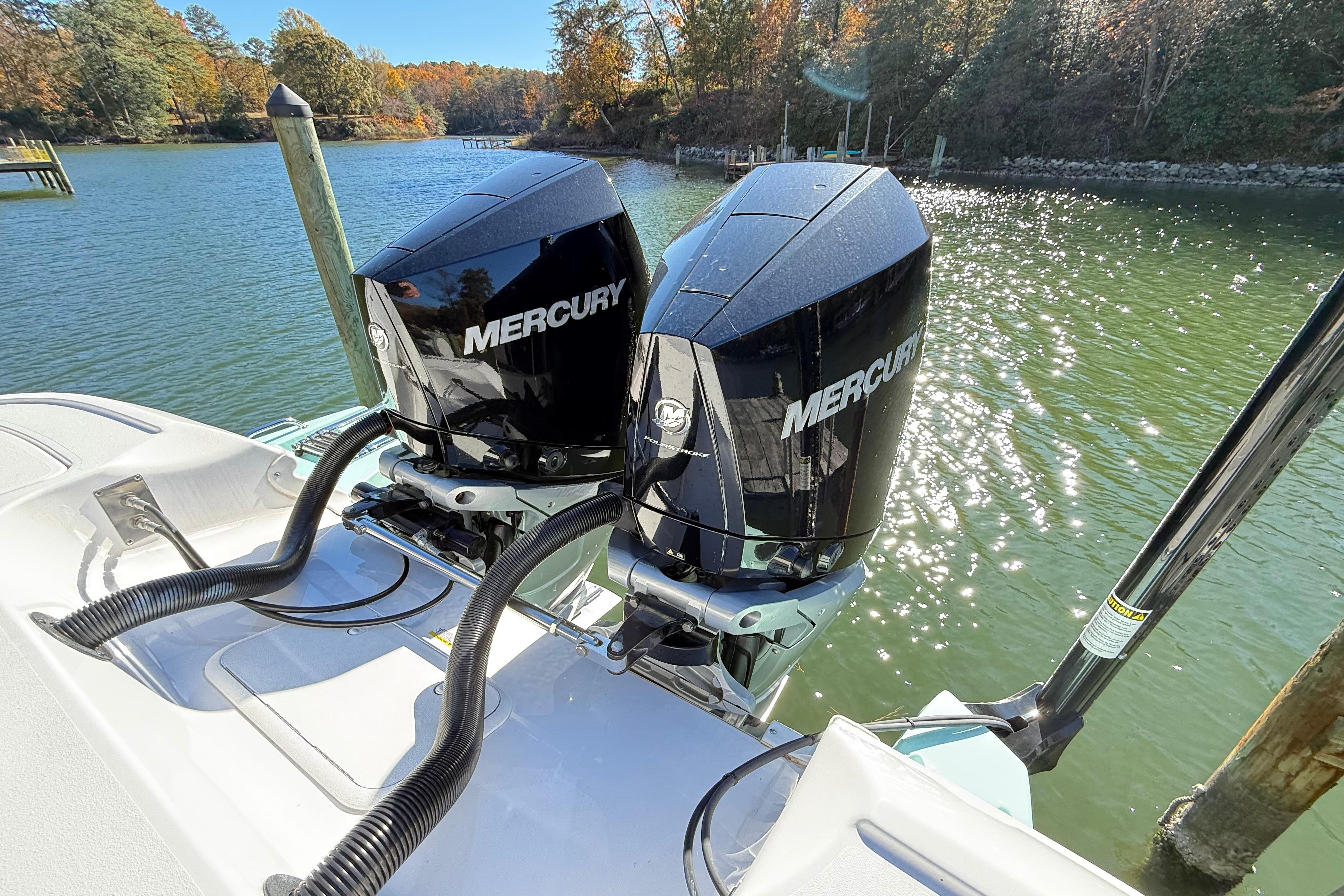 2023 Caymas 281 HB boat with dual Mercury outboard engines on a sunny lake.