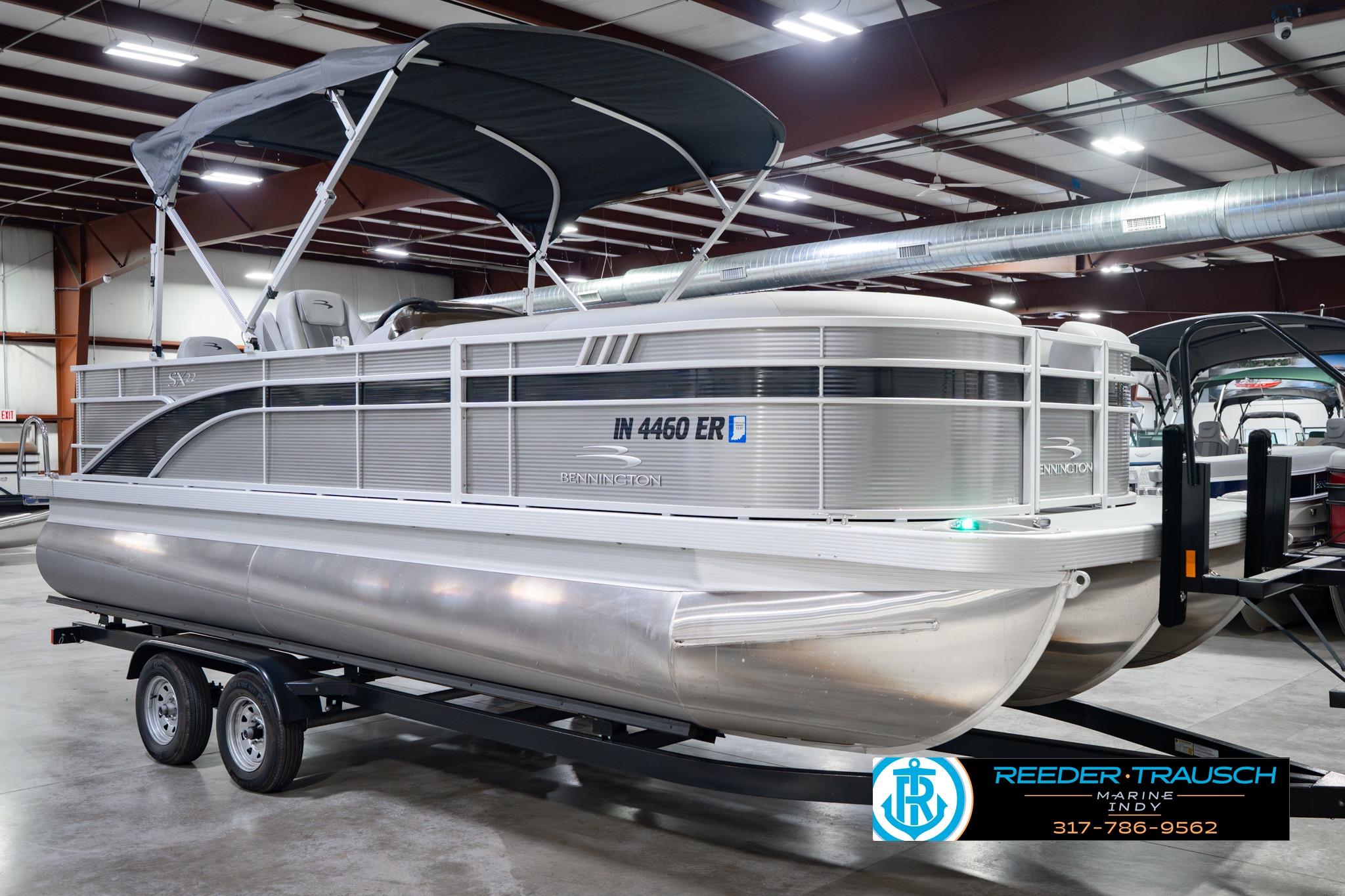 2026 Bennington 22 SXSAPG pontoon boat in showroom, featuring sleek design and canopy.