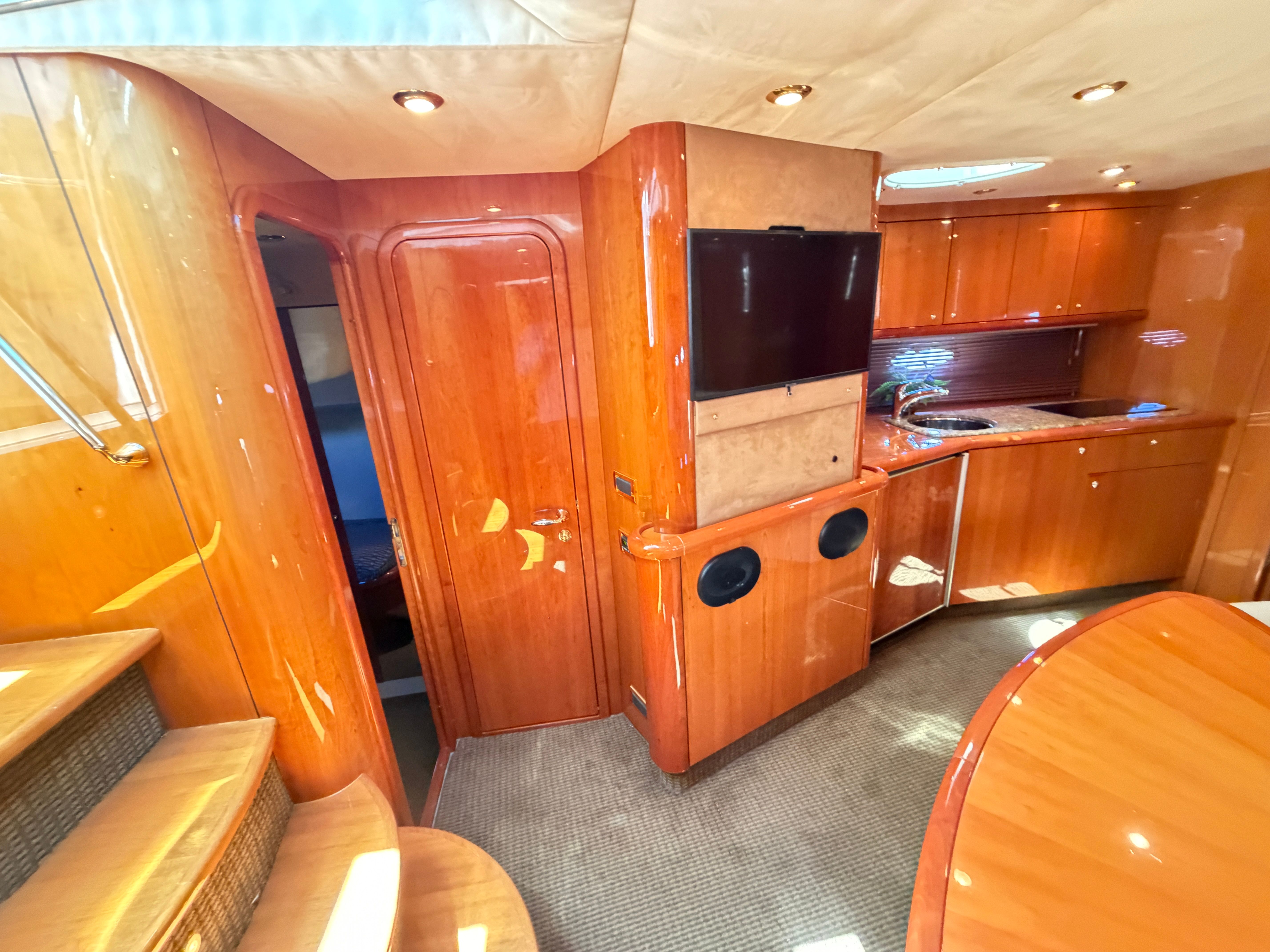 Interior of the 2008 Sunseeker Portofino 53 with wood finish and modern kitchen.