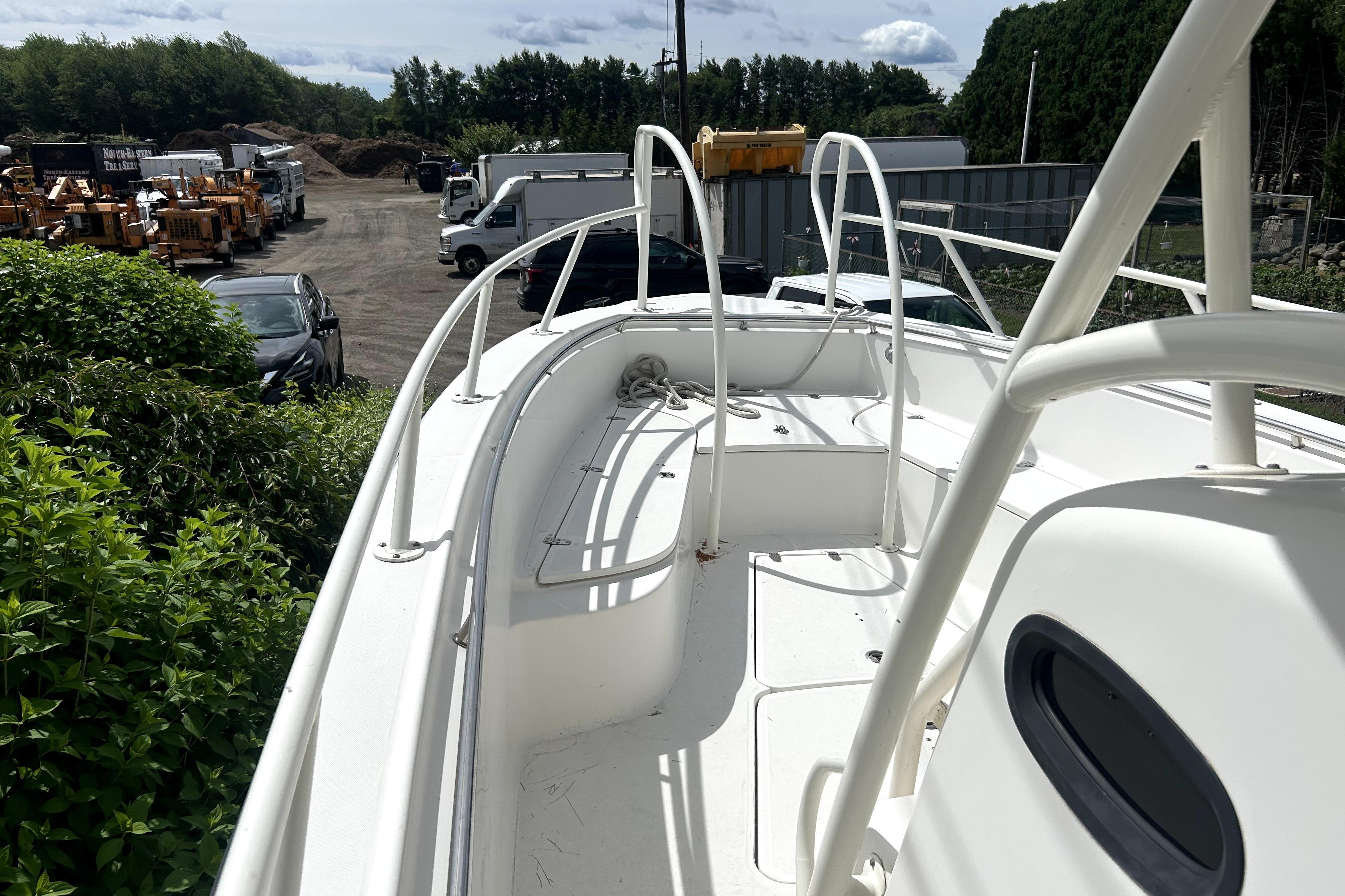 2012 Boston Whaler 320 Outrage boat docked in a yard with surrounding vehicles.