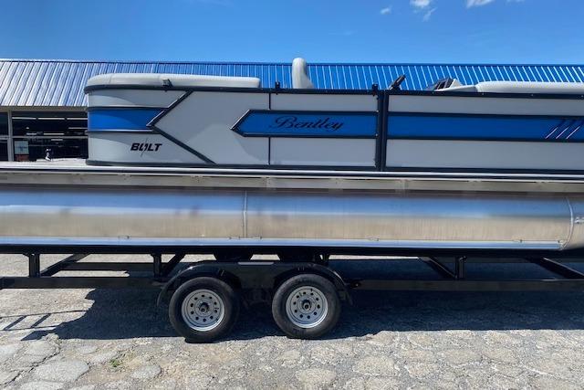 A 2026 Bentley Pontoons Bolt on a trailer, featuring a blue and gray design.