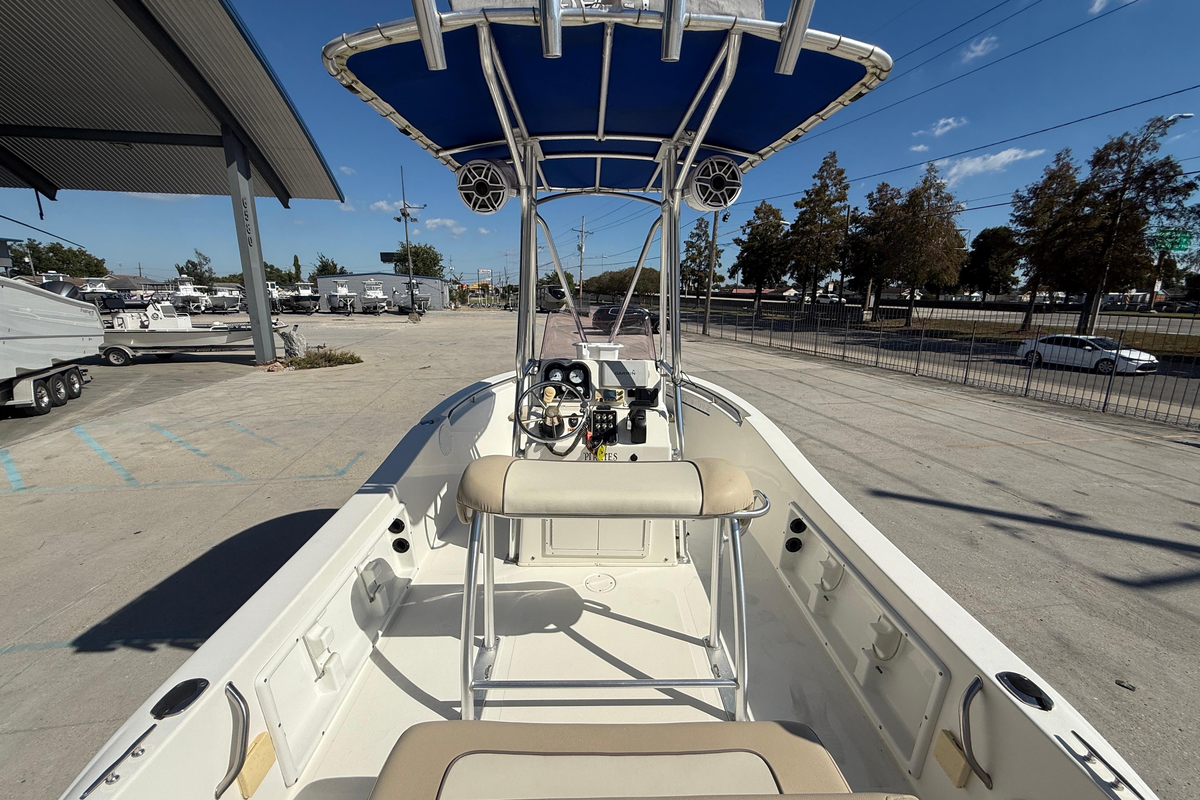 2019 NauticStar 19 XS boat with blue canopy, parked outdoors on a sunny day.