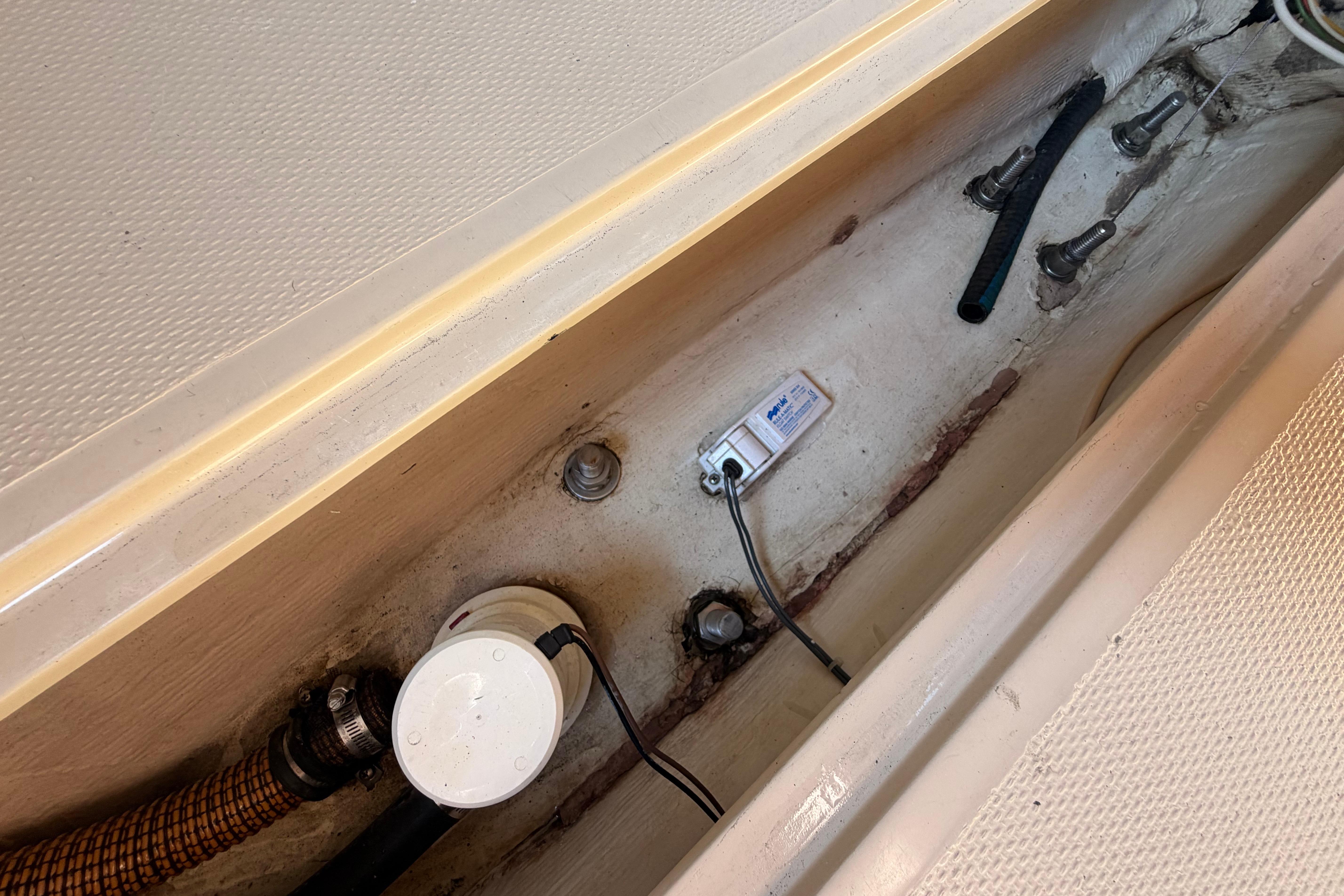 Bilge area of a 1988 Catalina 30 MkII sailboat with pump and wiring.