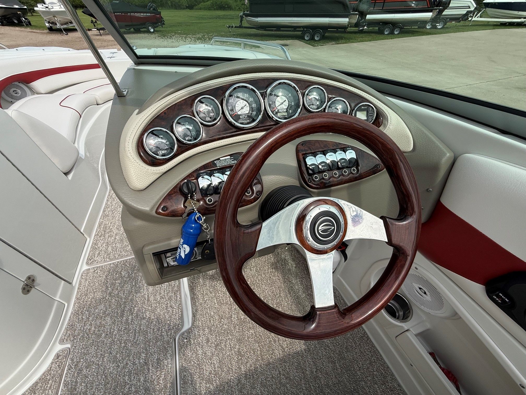 Dashboard of a 2012 Crownline 252 EX boat with wooden steering wheel and gauges.