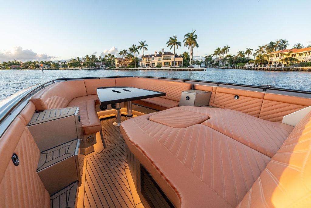 Luxurious 2023 DeKoning 43 yacht interior with elegant seating and scenic waterfront view.