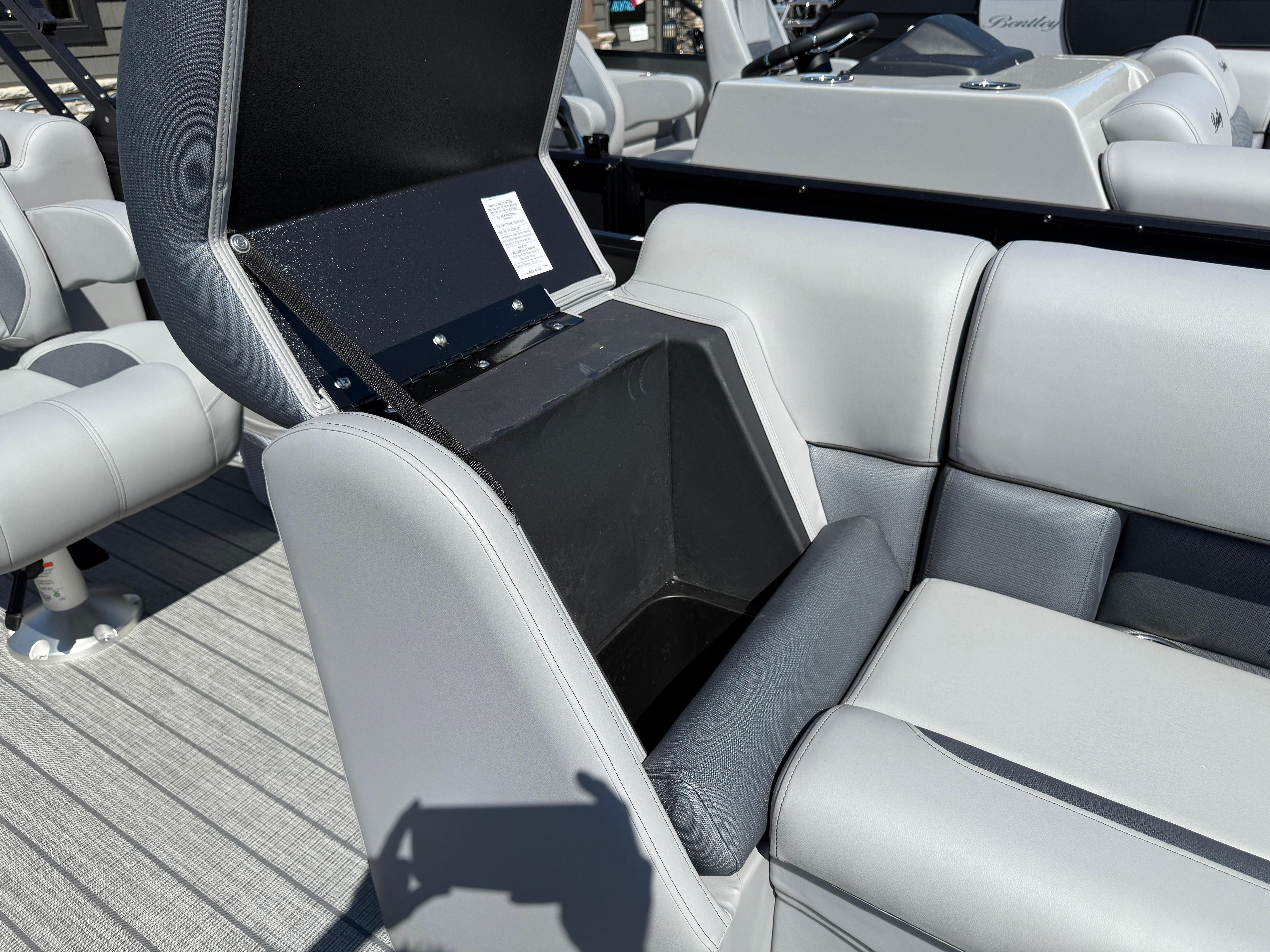 2026 Bentley Pontoons Legacy 223 Navigator seat storage compartment, open on a luxury boat.