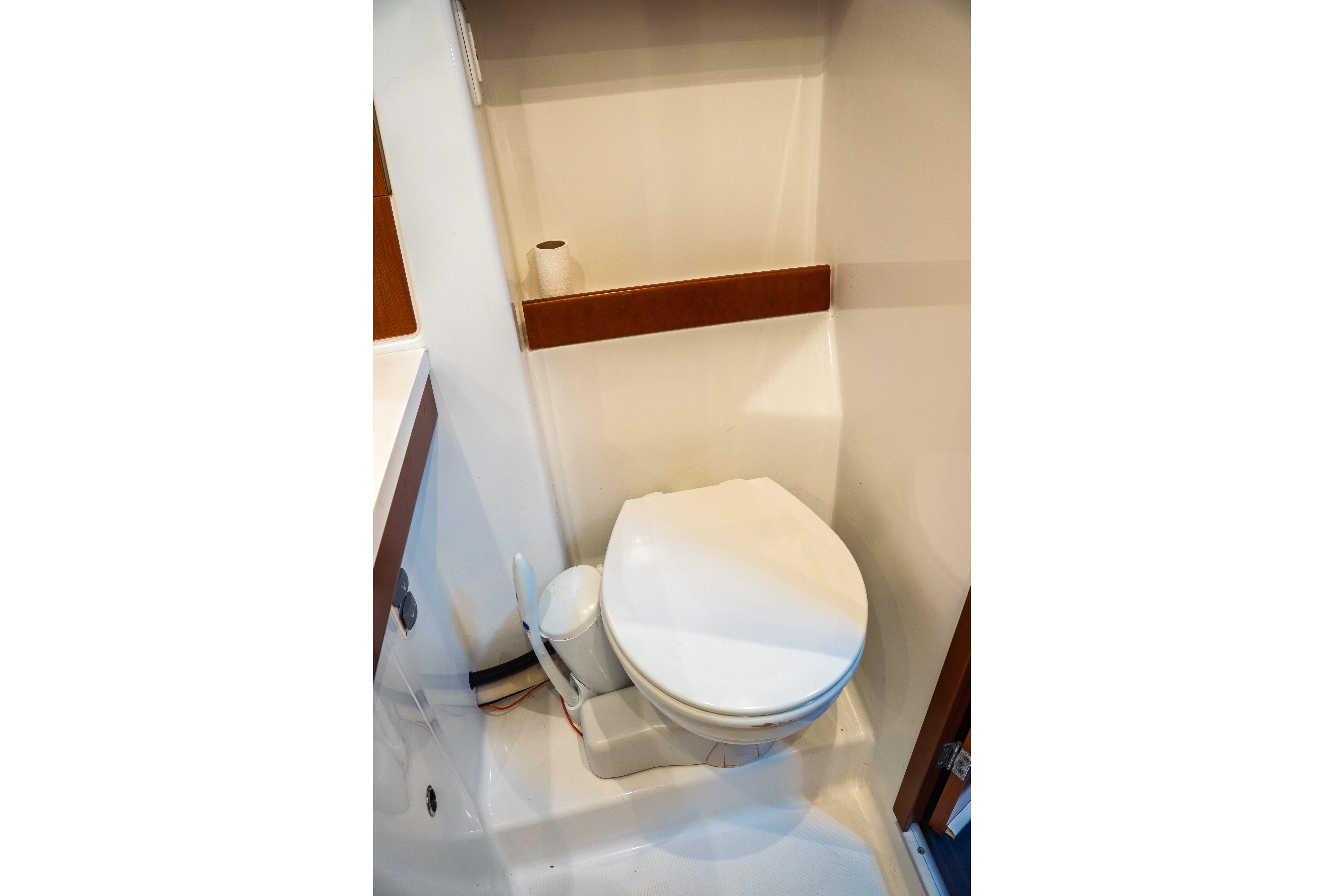 Toilet area in 2011 Beneteau Oceanis 50 yacht, featuring compact design and white finish.