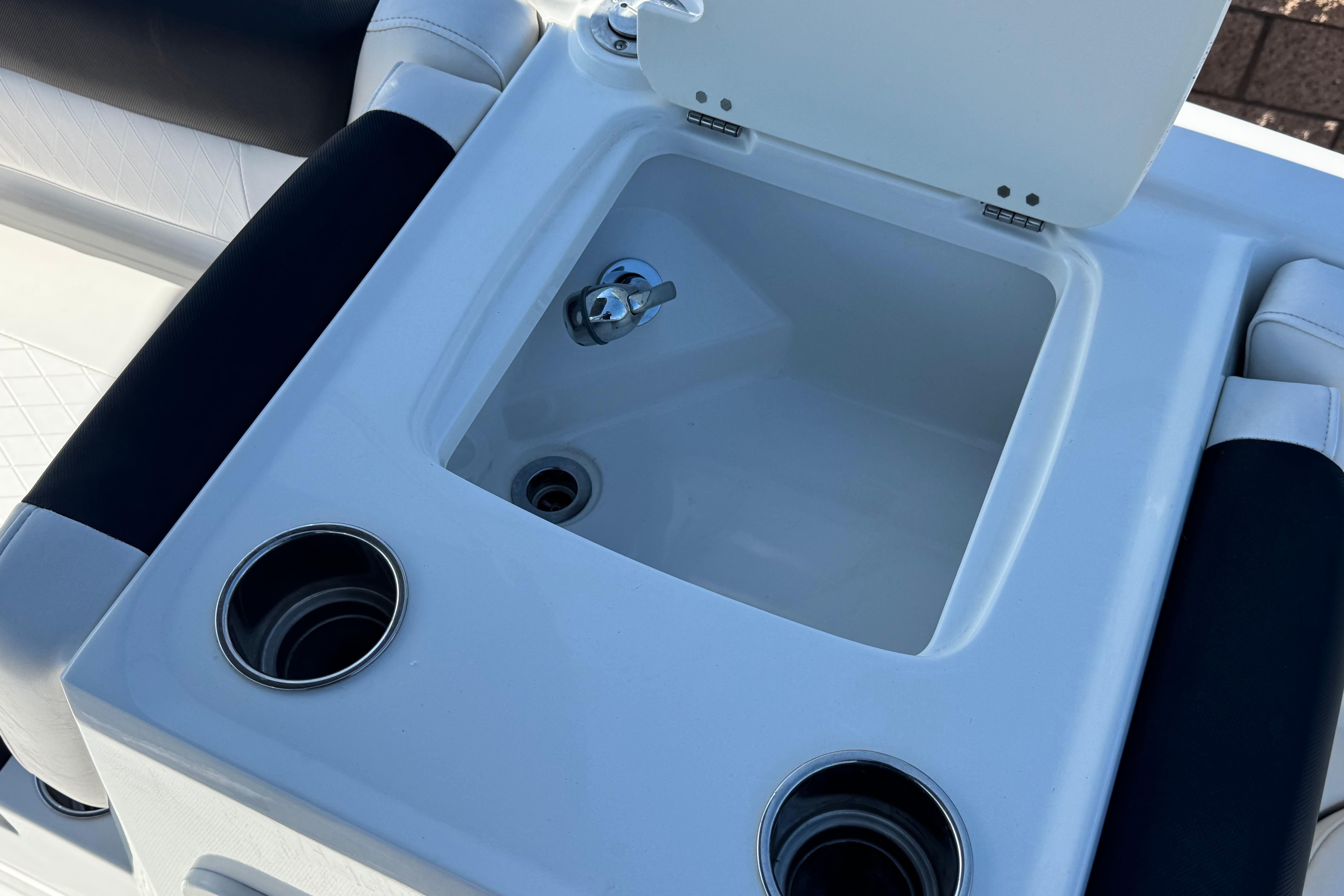2019 Tahoe 2150 boat sink with cup holders and open lid.