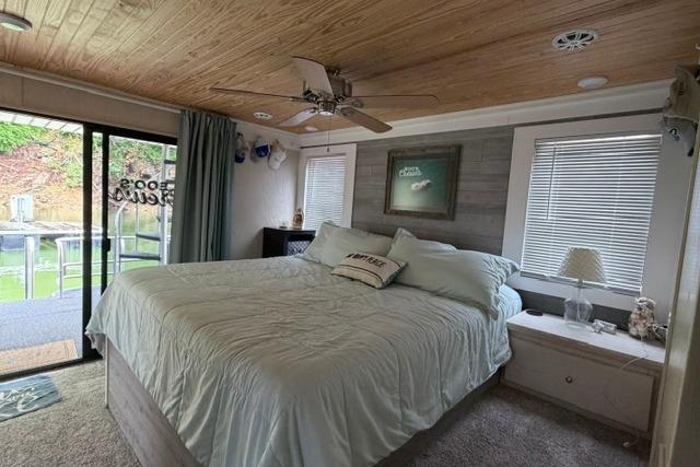 Cozy bedroom in 1997 Stardust Houseboat 18x83 with wood ceiling and large bed.