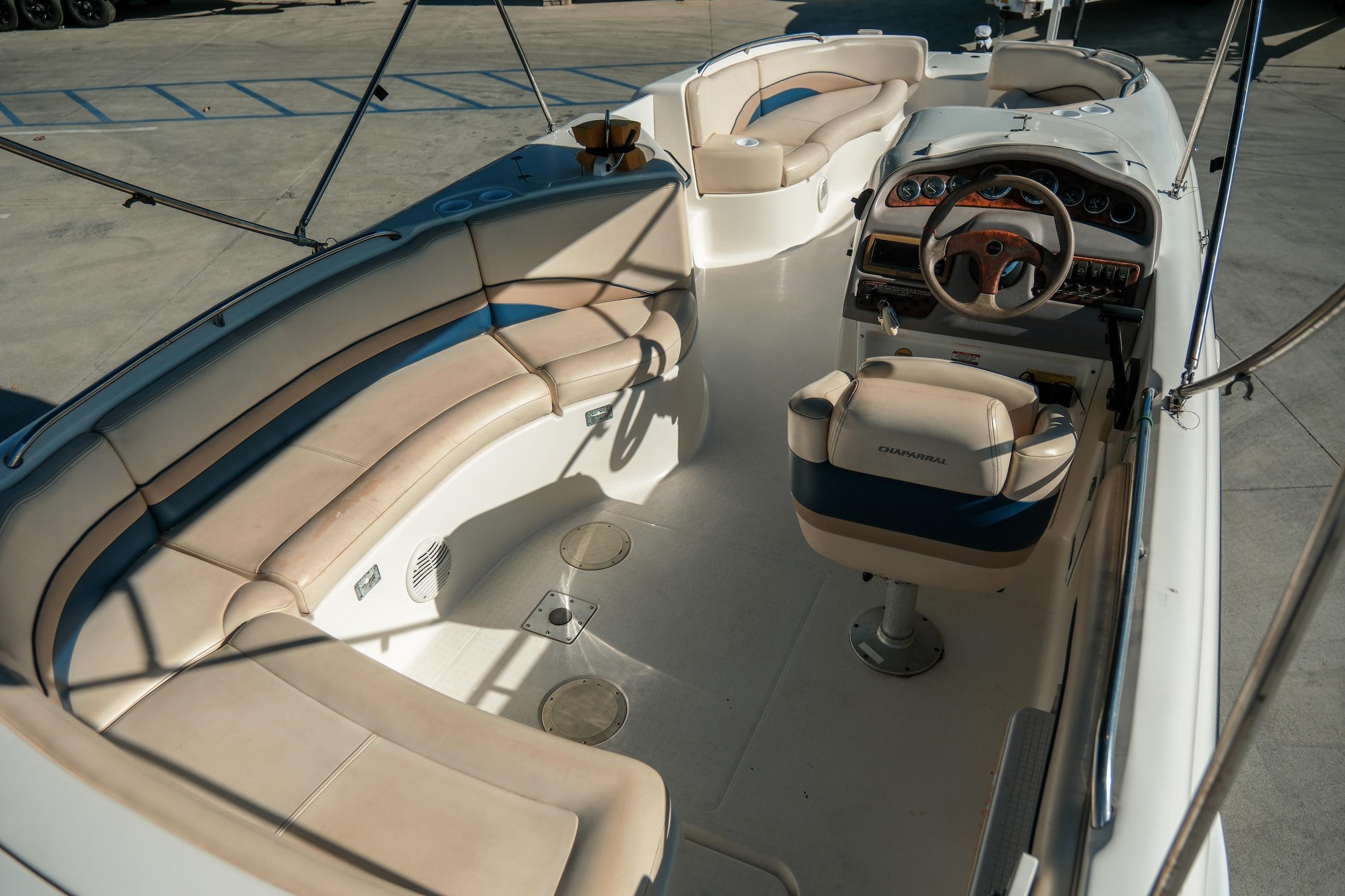 1998 Chaparral 232 Sunesta boat interior with beige seating and steering console.