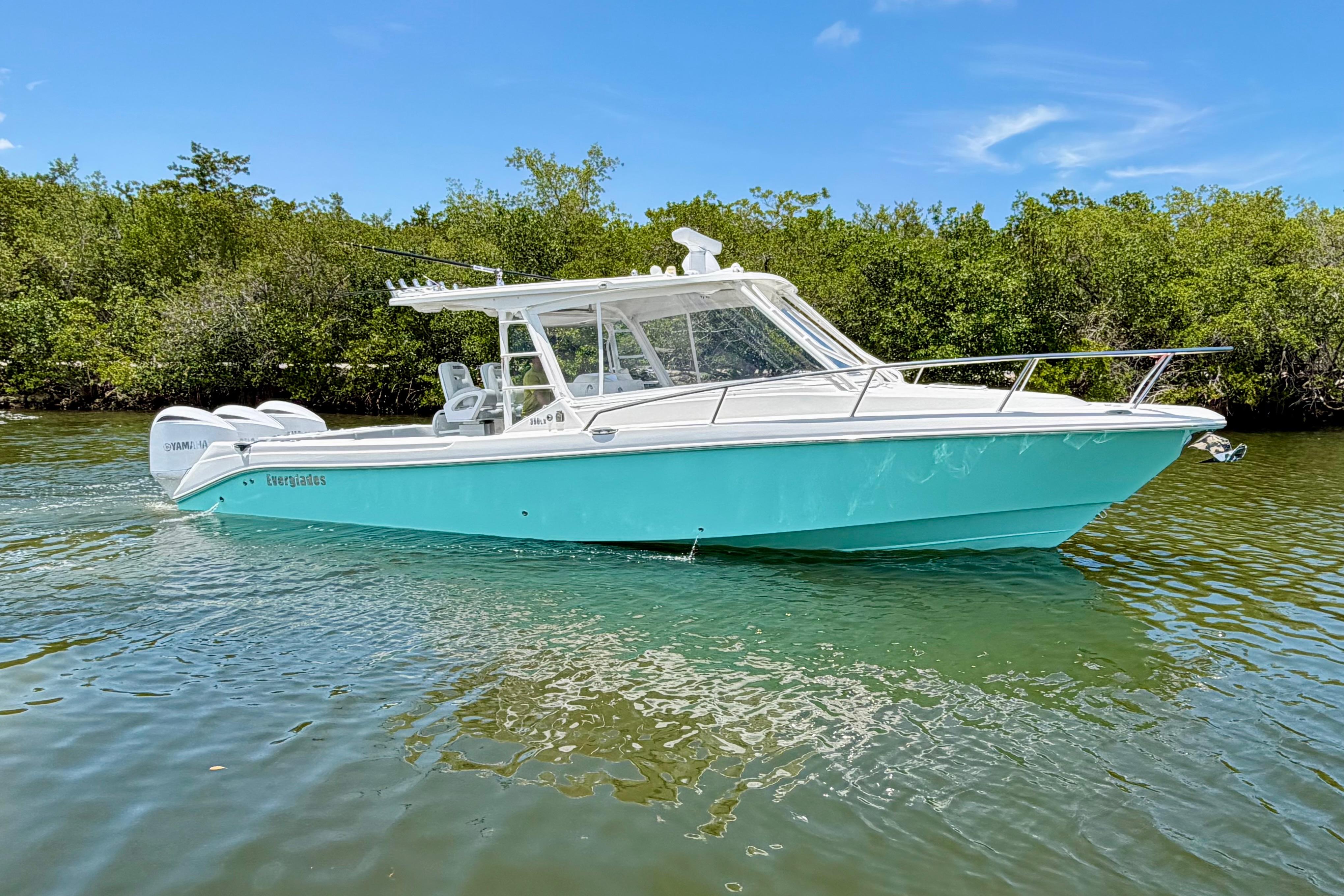 2009 Everglades 350LX boat on calm water, surrounded by lush greenery.
