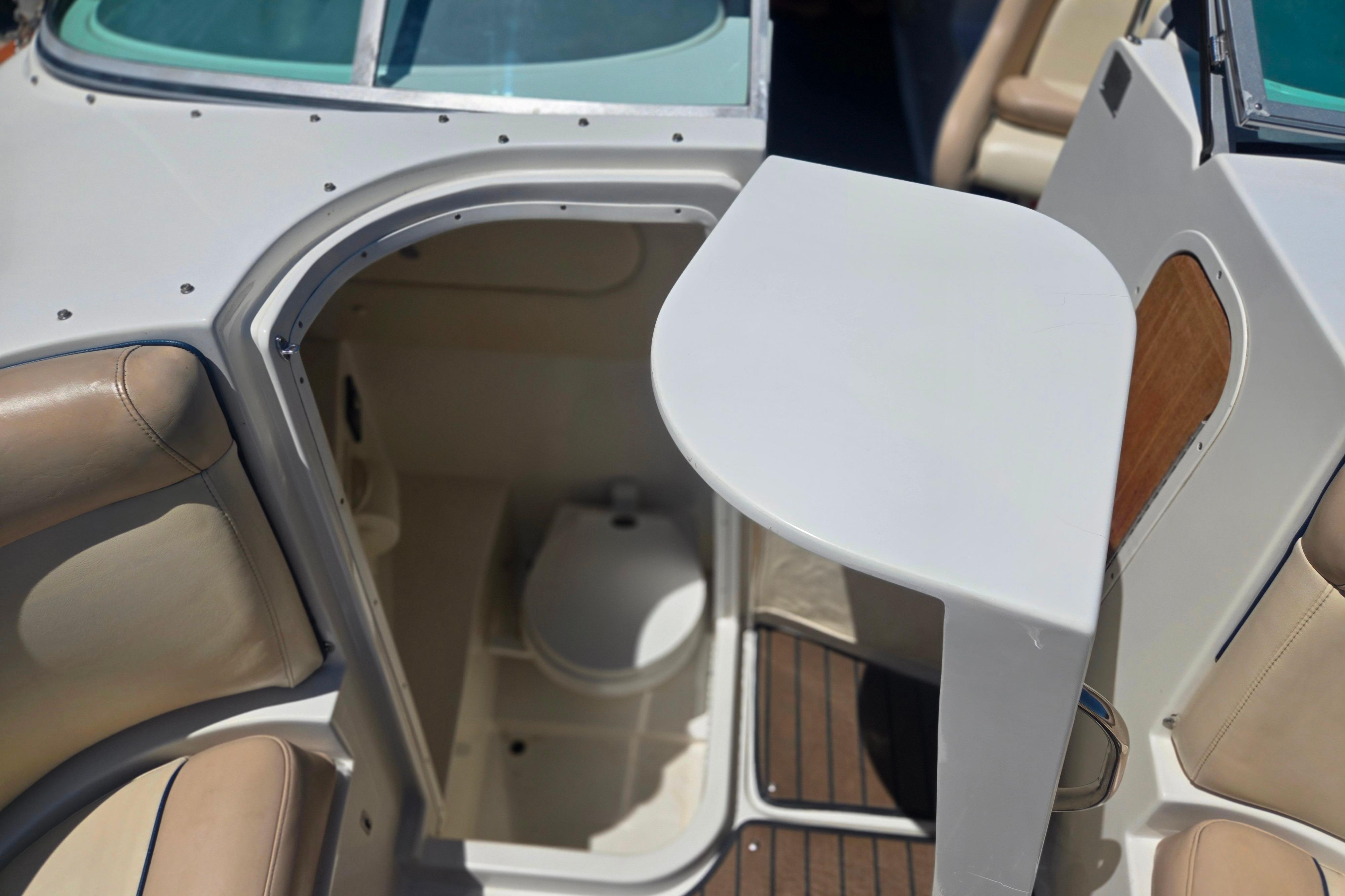 Interior view of 2002 Chris-Craft Launch 28 GT I/O boat with seating and compact restroom.