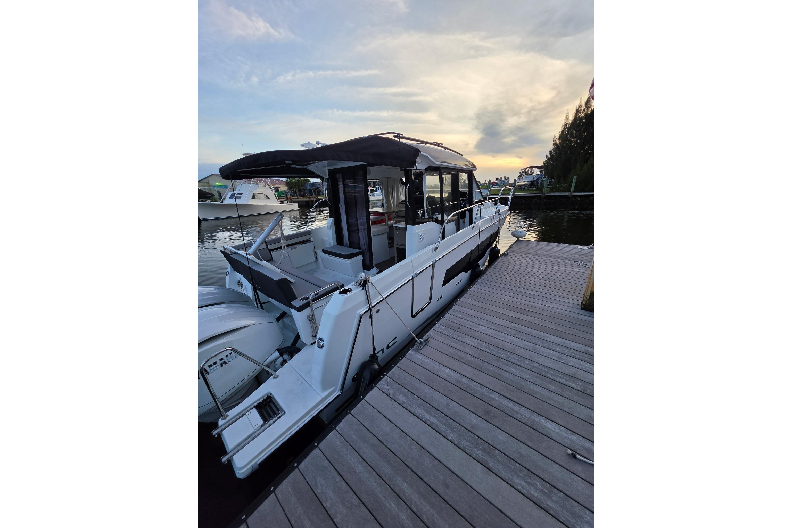 2026 Jeanneau NC 895 Series 2 docked at sunset, showcasing sleek design and modern features.
