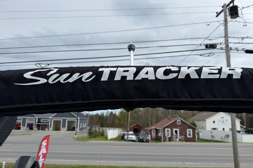 Sun Tracker Party Barge 16 DLX 2025 canopy with logo, roadside view.