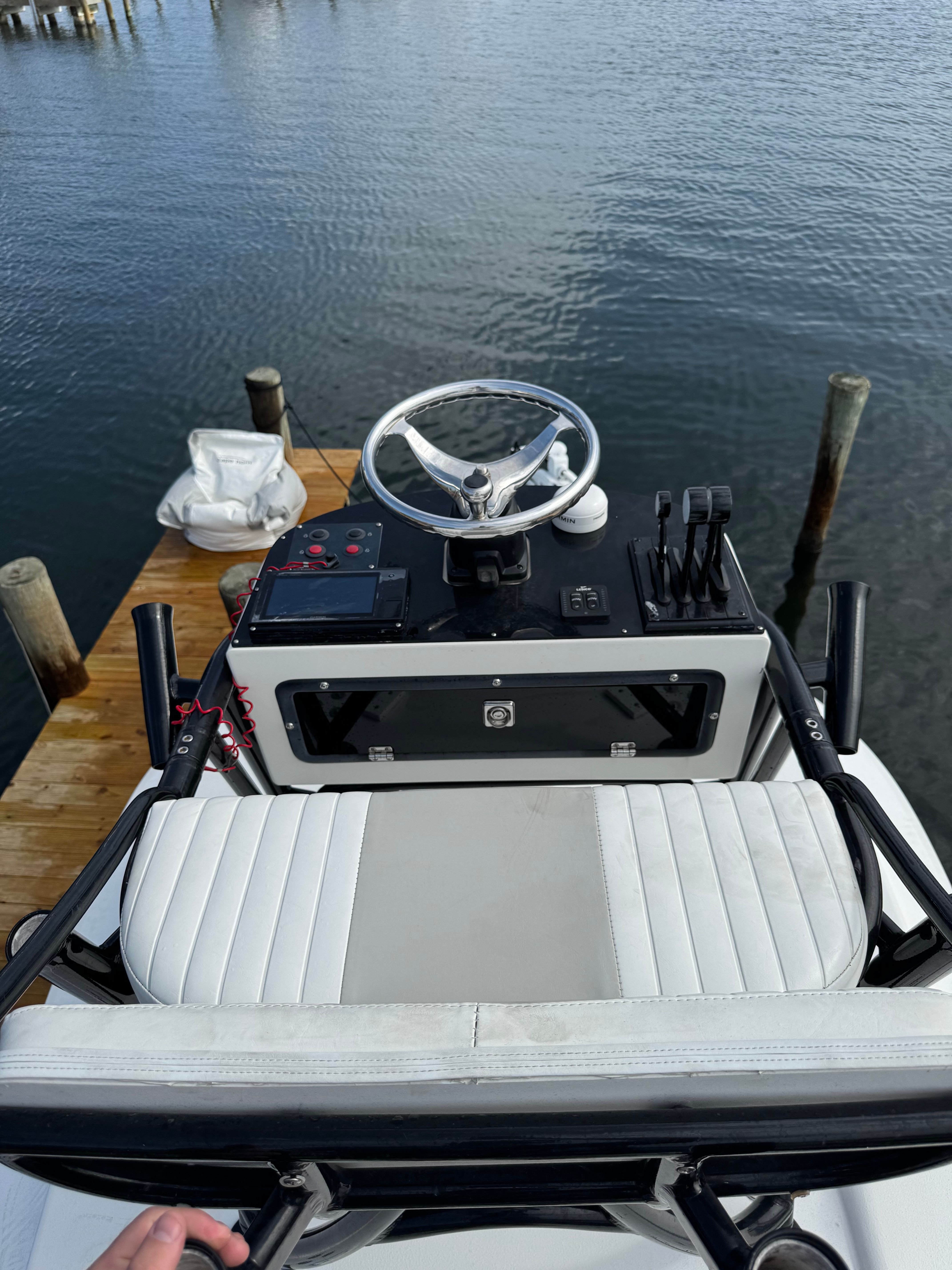 The image shows the helm of a 2014 Cape Horn 24XS boat docked by a pier.