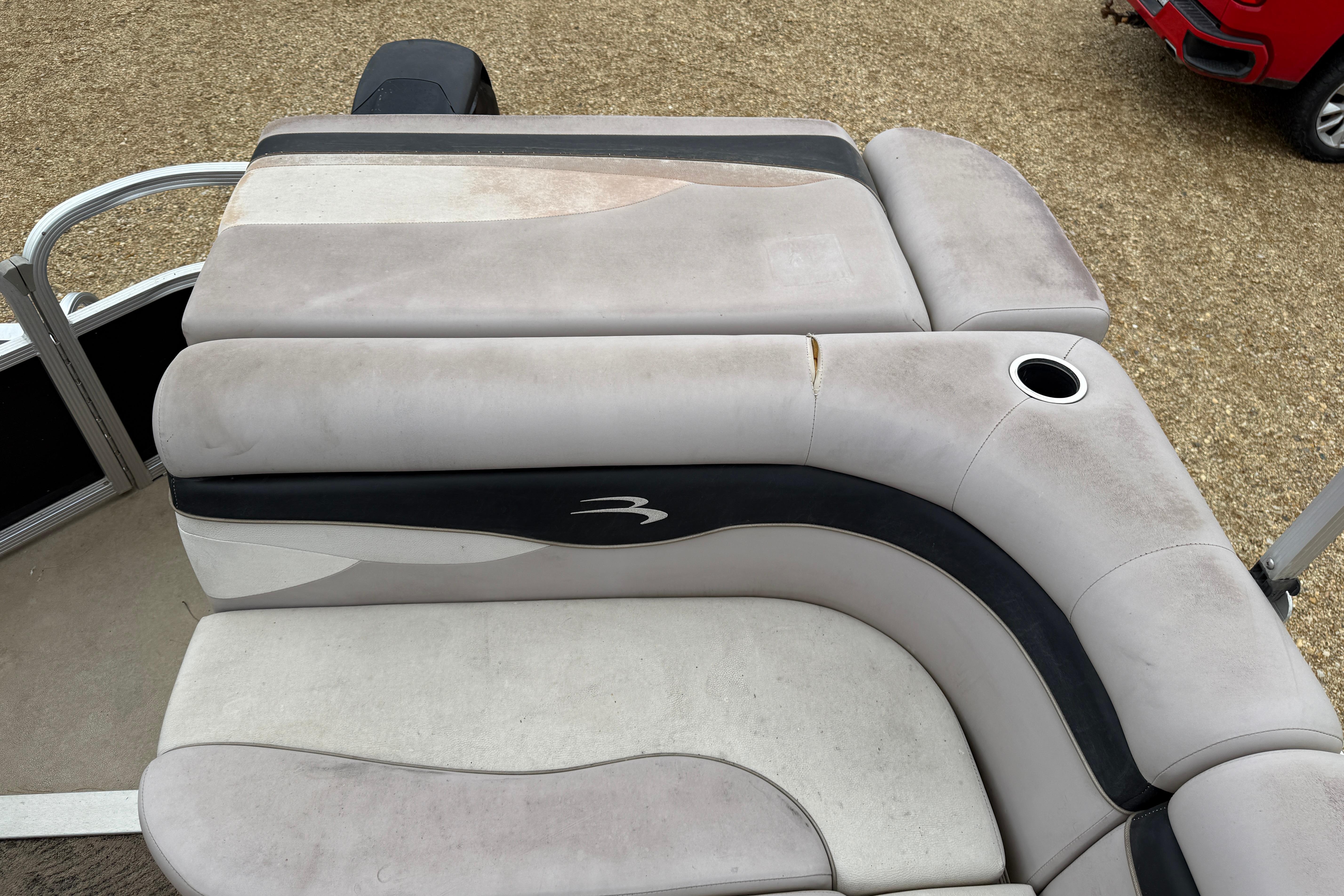 2010 Bennington 20SLi boat seating with visible wear and cup holder.
