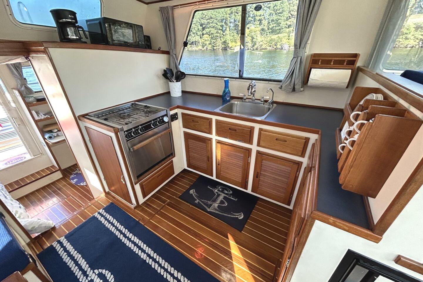 1997 Rosborough Trawler kitchen interior with stove, sink, and wooden cabinetry.