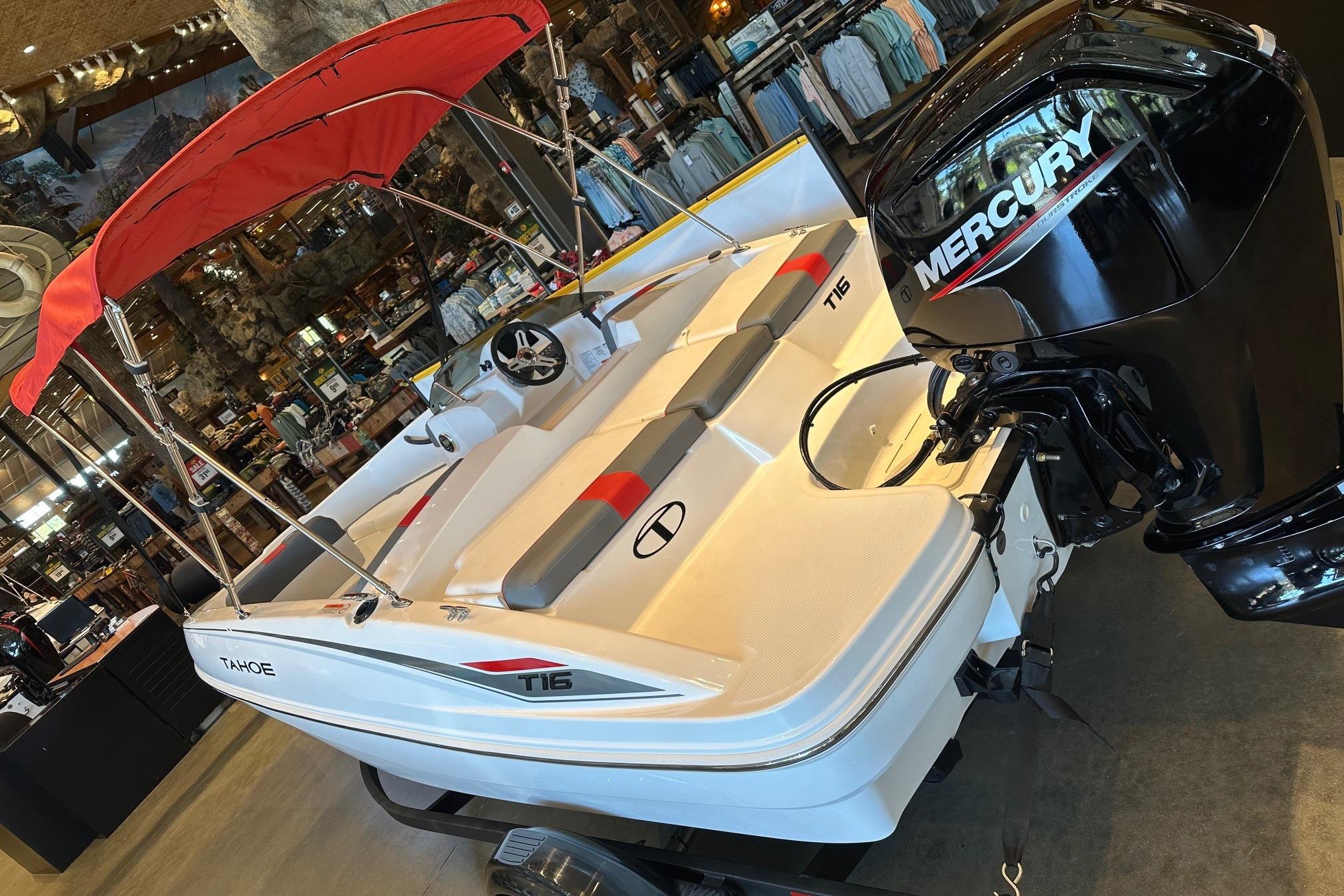 2025 Tahoe T16 boat with Mercury engine, red canopy, displayed indoors.