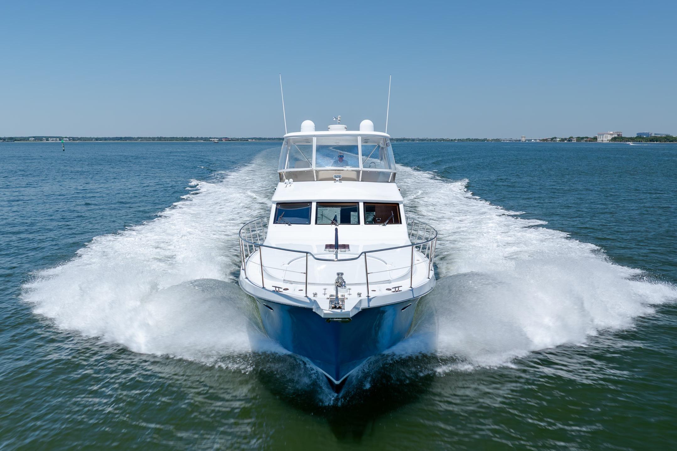 Ocean Alexander yacht cruising swiftly on open water under clear blue skies.