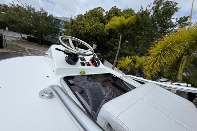 2025 Contender 26 Bay boat helm with steering wheel and lush greenery background.
