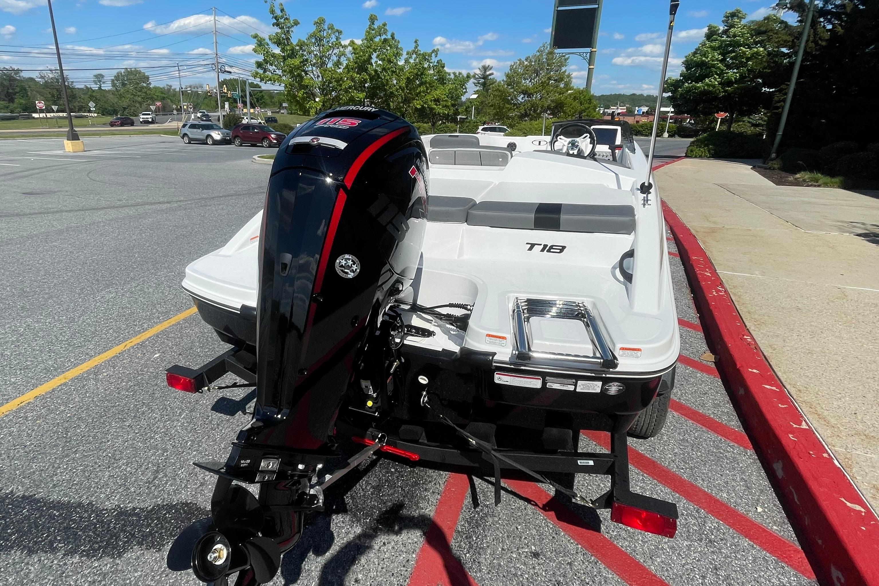 2026 Tahoe T18 boat with outboard motor in a parking lot.