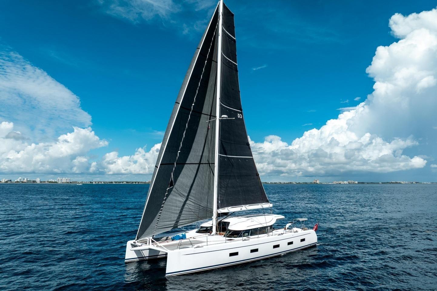 2019 Ocean Explorer Catamarans 60 sailing on open sea under clear blue sky.
