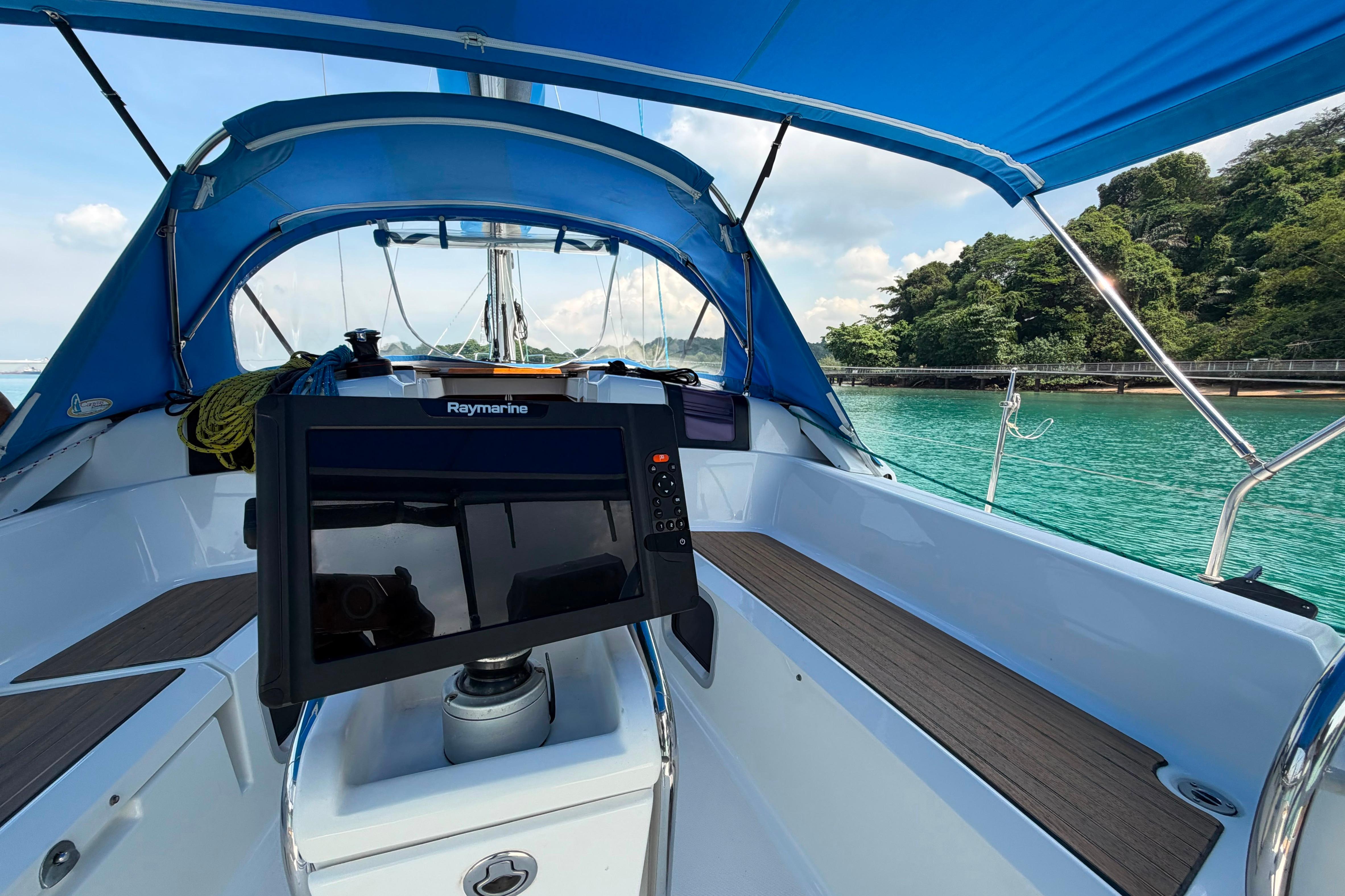 Cockpit view of 2013 Jeanneau Sun Odyssey 379 sailboat with blue canopy and Raymarine equipment.