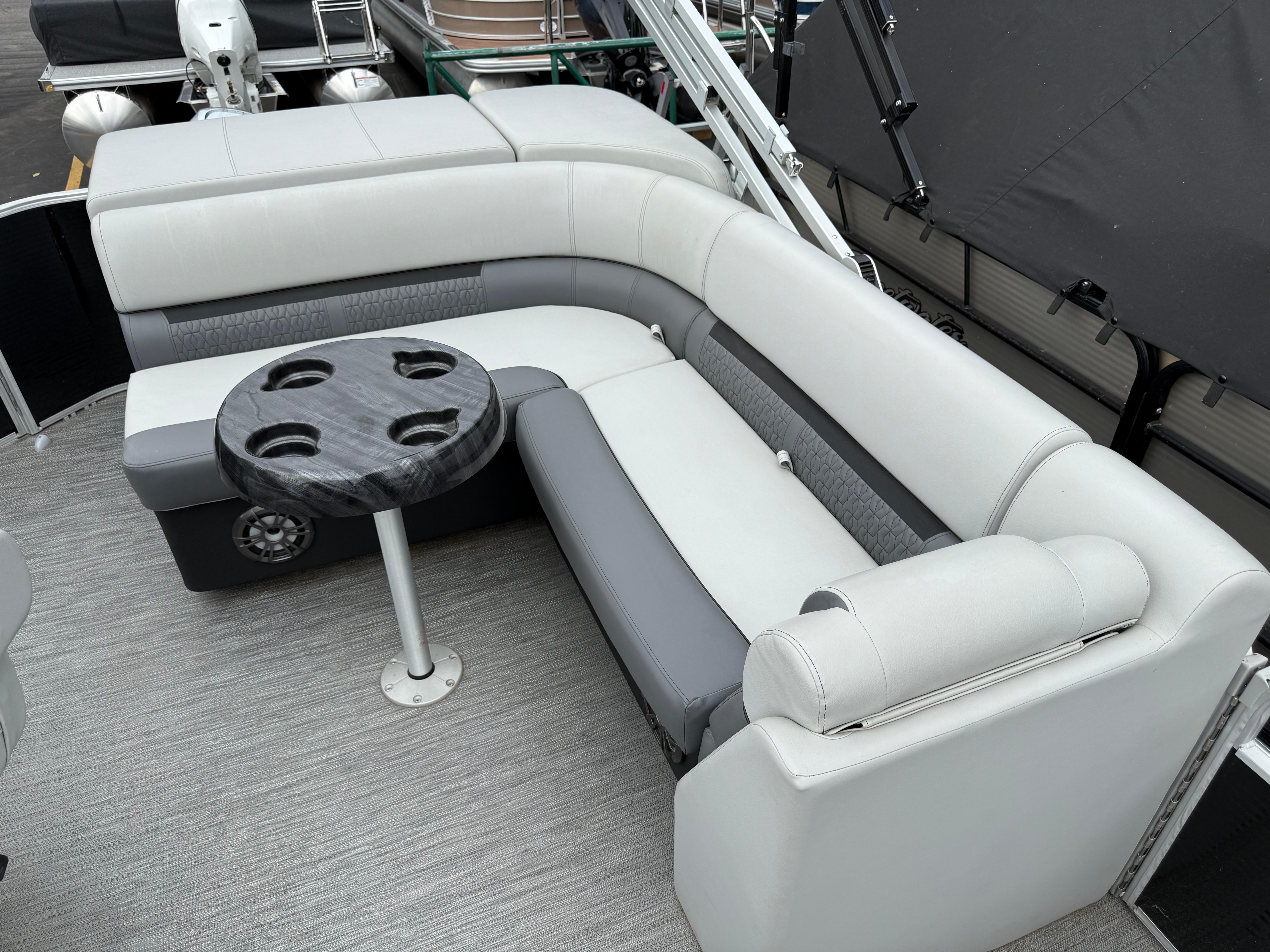 2023 Godfrey Sweetwater boat interior with gray seating and round table.