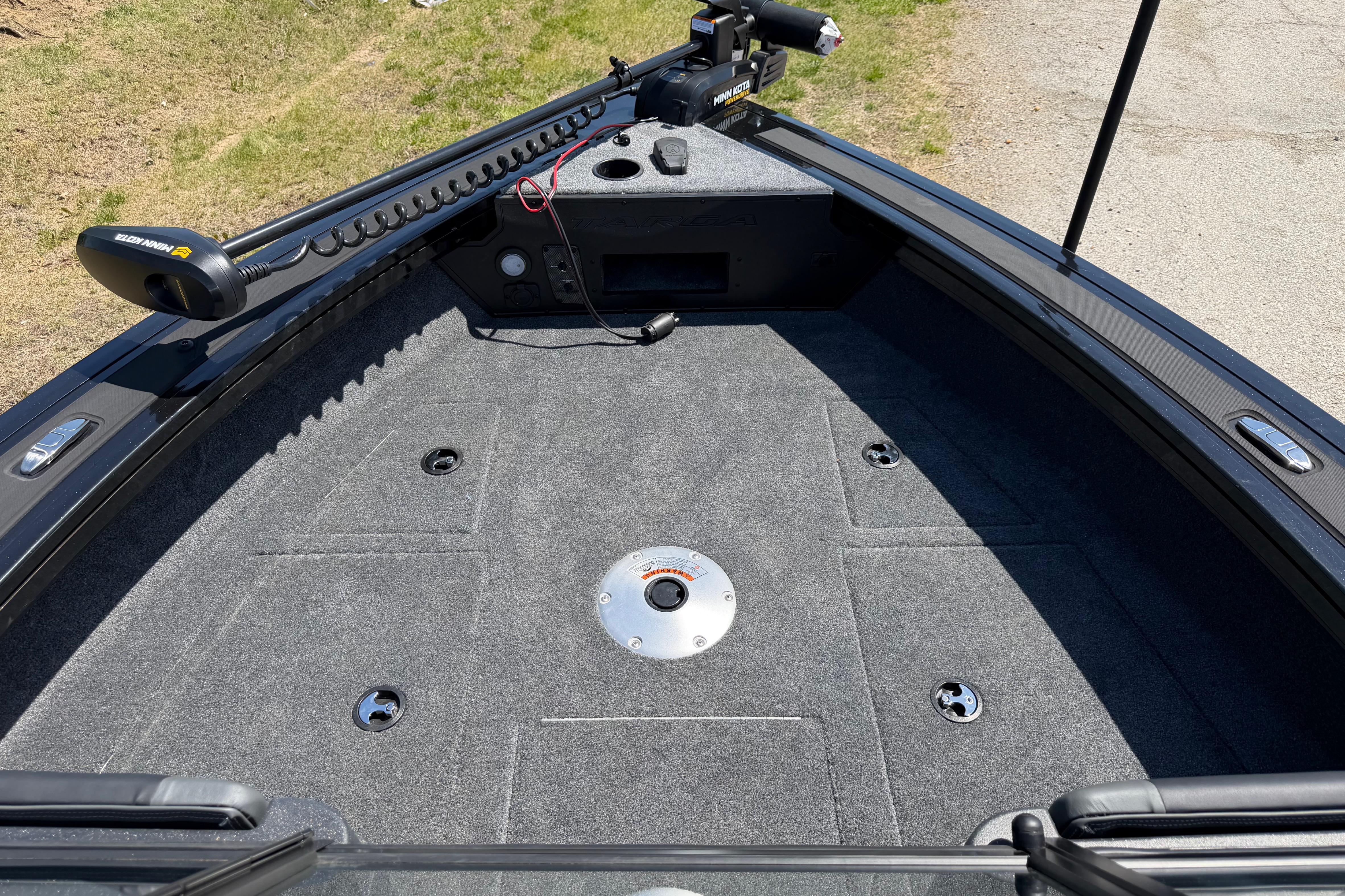 2026 Tracker Targa V-19 WT boat deck with trolling motor, carpeted surface, and storage compartments.