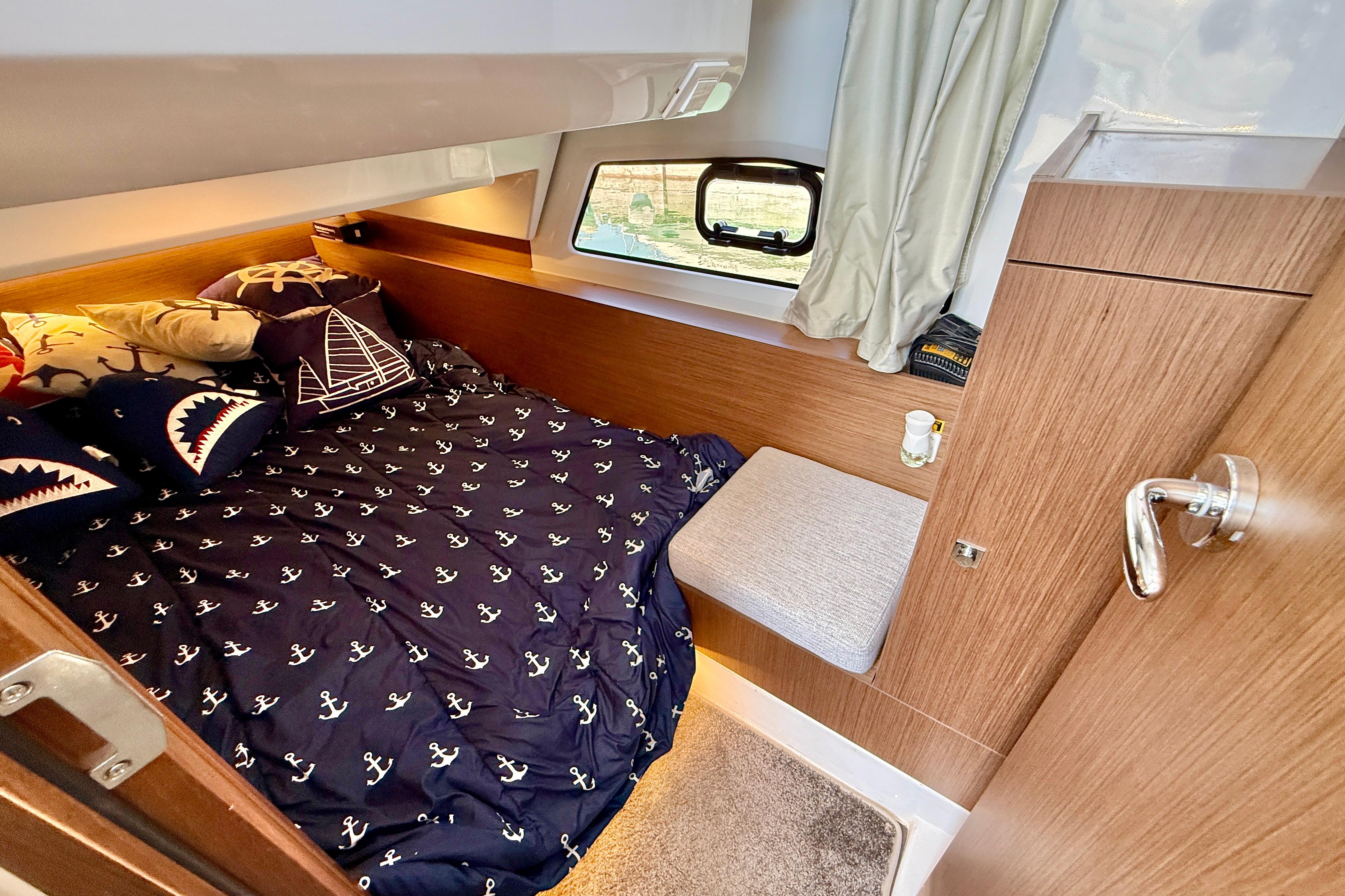 Cozy cabin interior of 2022 Jeanneau NC 1095 Fly with nautical-themed bedding.