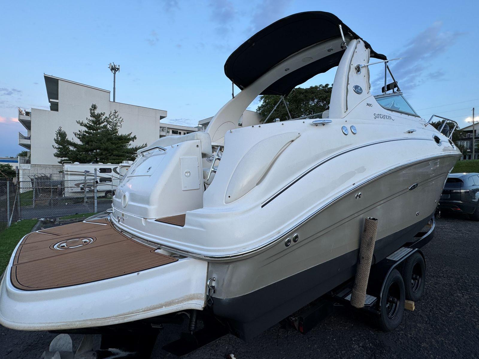2006 Sea Ray 280 Sundancer boat on trailer, white exterior, docked outdoors.