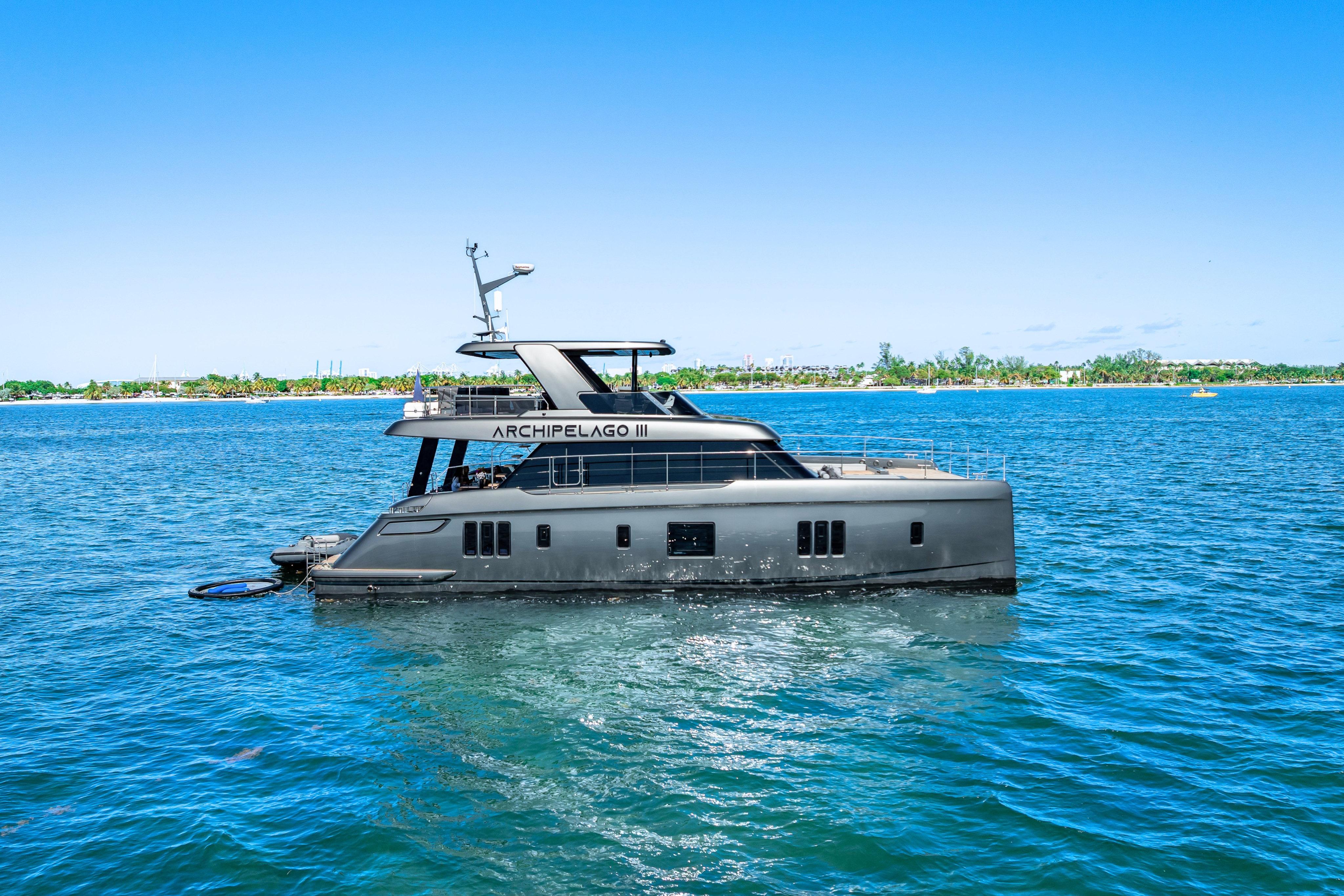 2026 Sunreef 60 Power yacht on blue ocean near tropical shoreline.