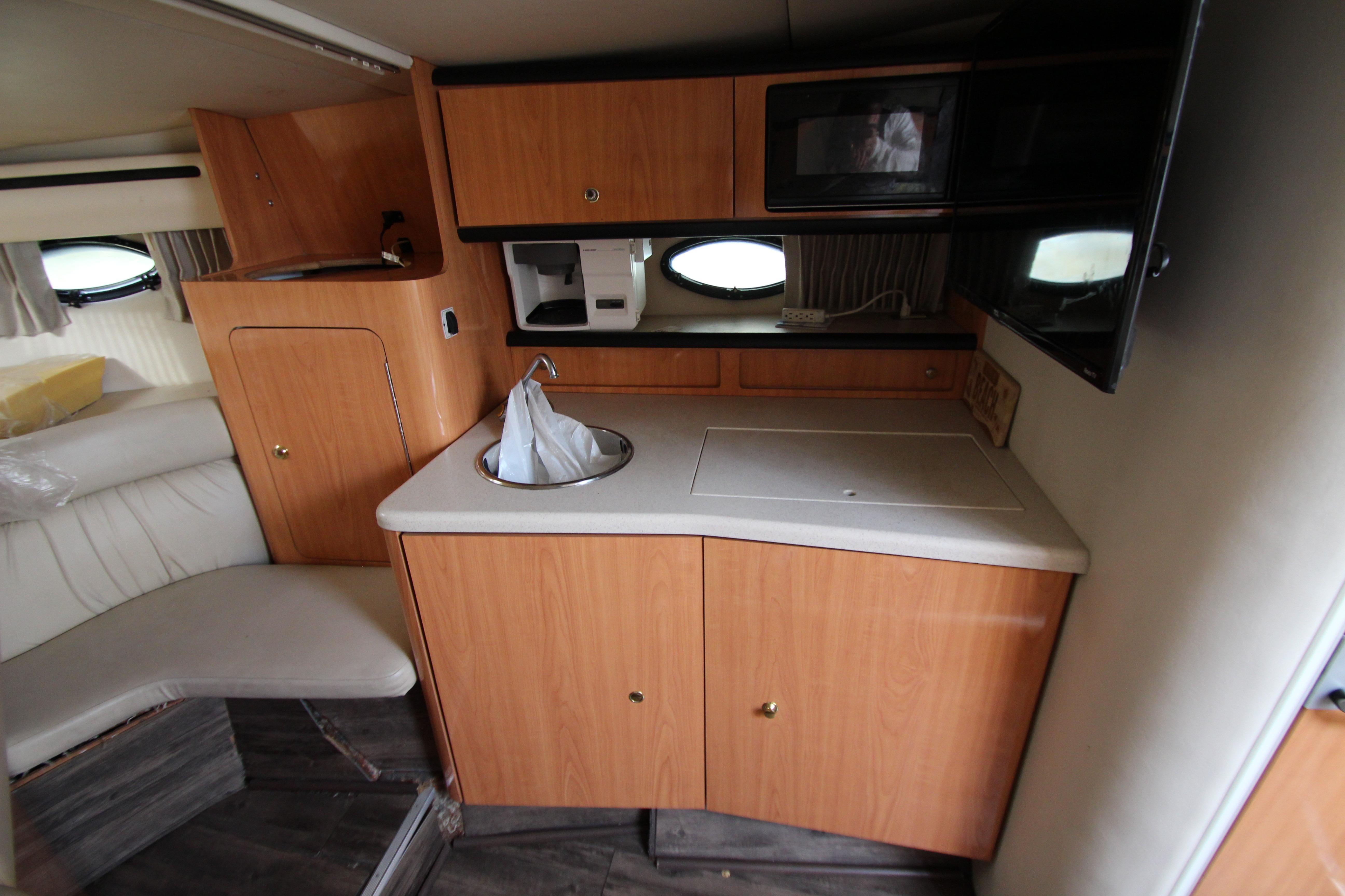 1999 Regal Commodore 322 boat interior with kitchenette, sink, and microwave.