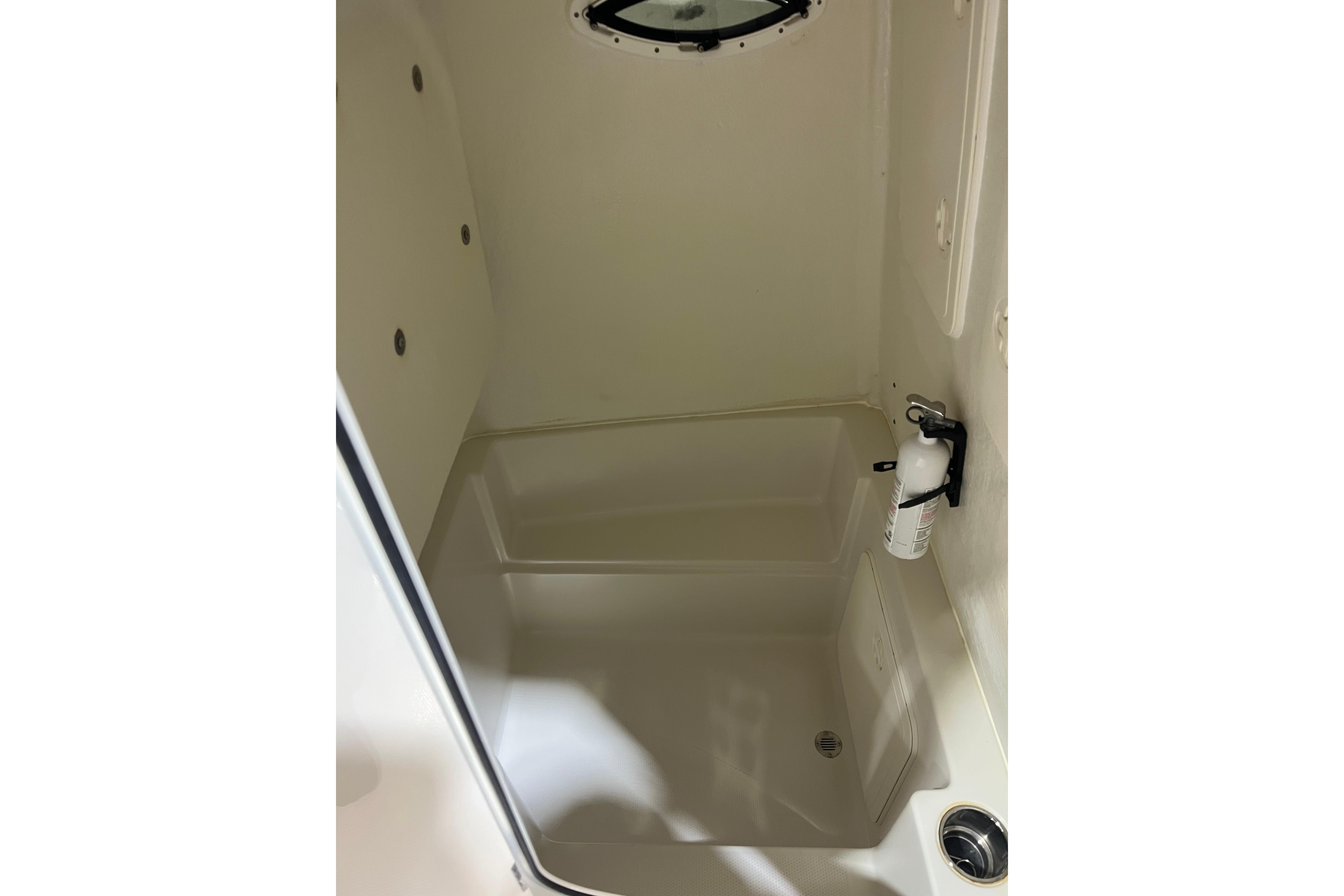 Interior of 2022 Sailfish 242 CC boat, featuring a compact storage area with a fire extinguisher.