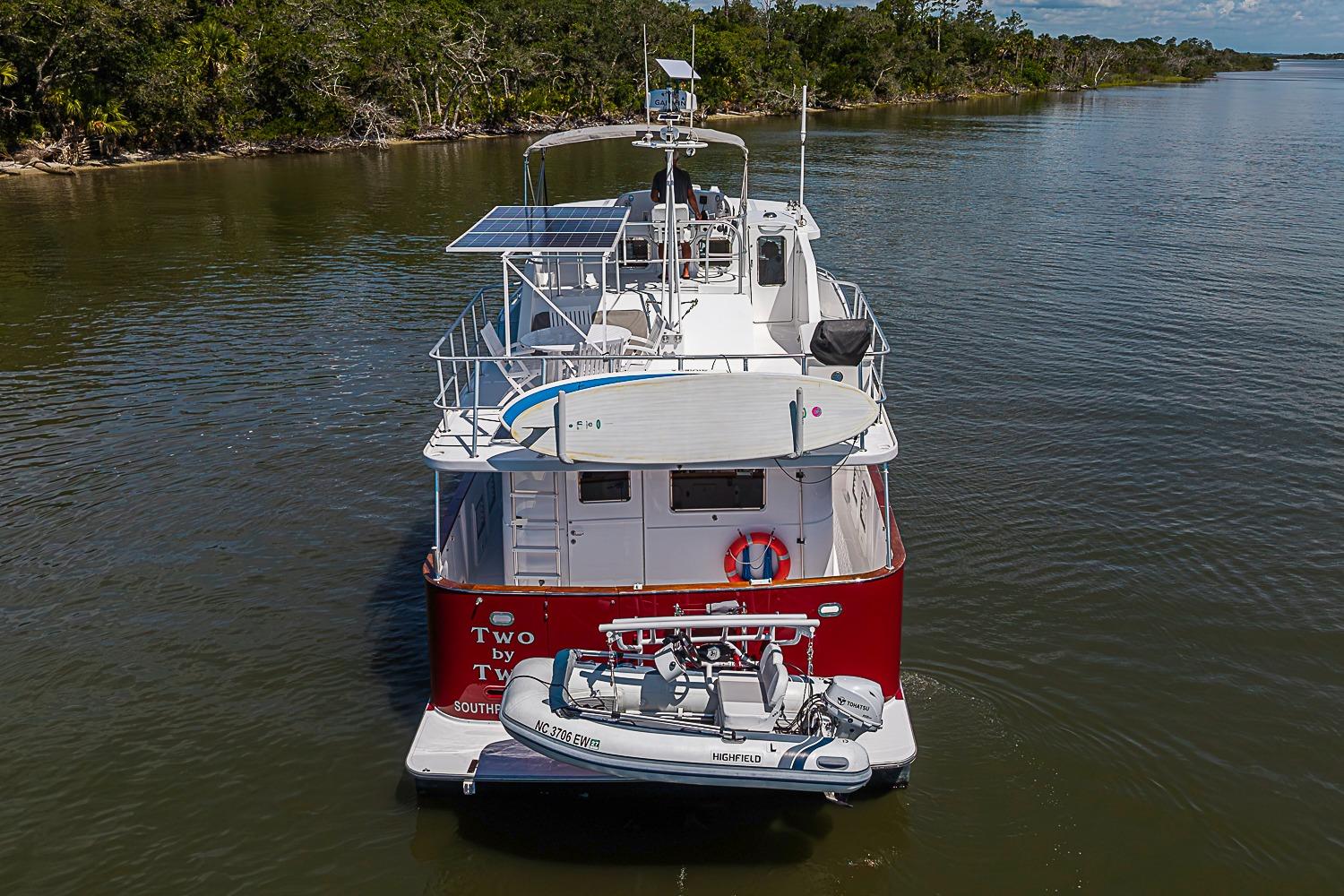 Magna Marine Nova Scotia 47 boat, 2003 model, with solar panels and dinghy on calm water.