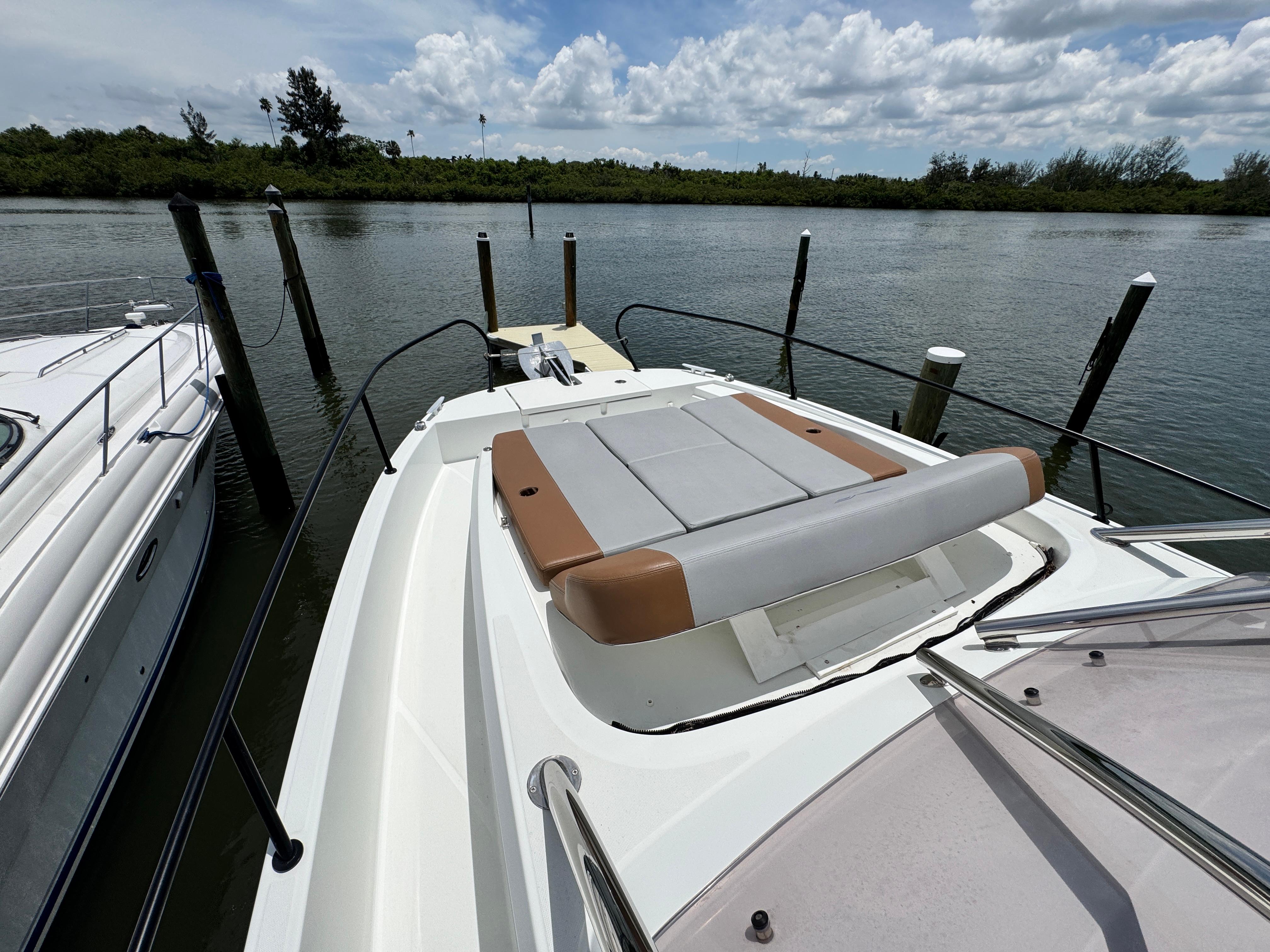 2022 Beneteau Flyer 9 SUNdeck moored by a serene waterfront, showcasing its spacious deck.