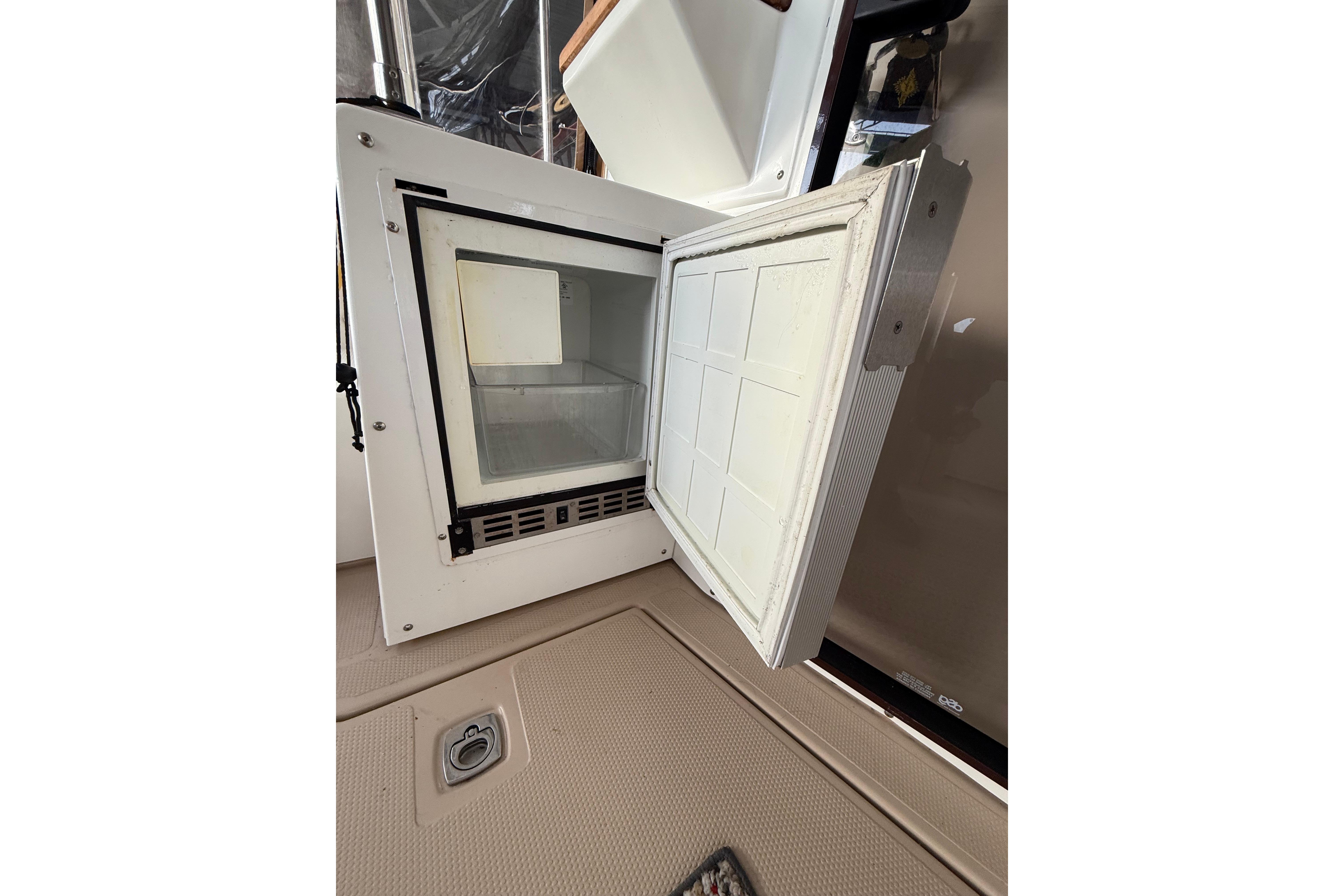 Open refrigerator on 2016 Ranger Tugs R-31 CB boat, showing interior storage space.