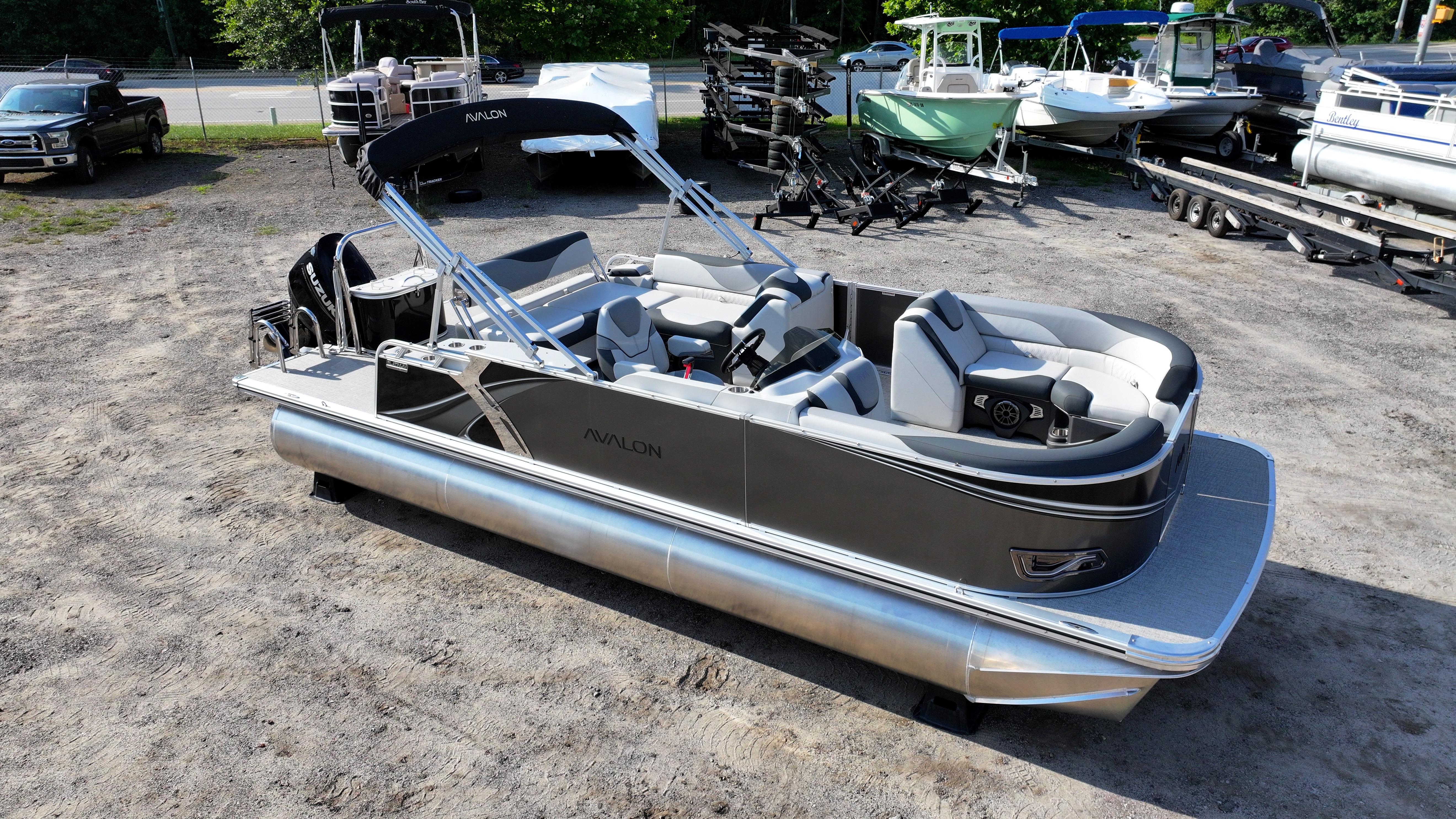 2025 Avalon LSZ Cruise Rear Bench pontoon boat in a parking lot.
