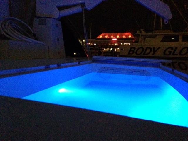 Sunseeker MANHATTAN 1995 yacht with illuminated blue pool at night.