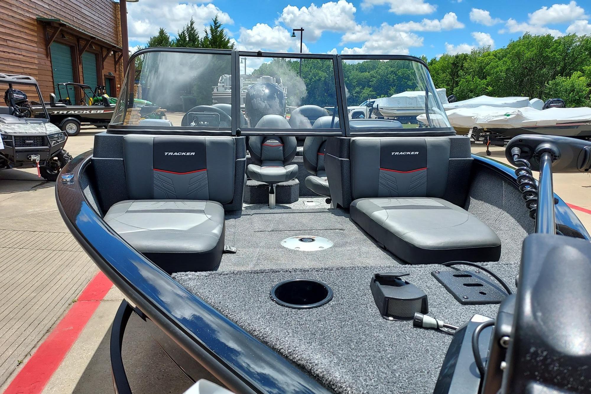 2026 Tracker Pro Guide V-175 Combo boat with seating, parked outdoors under a blue sky.