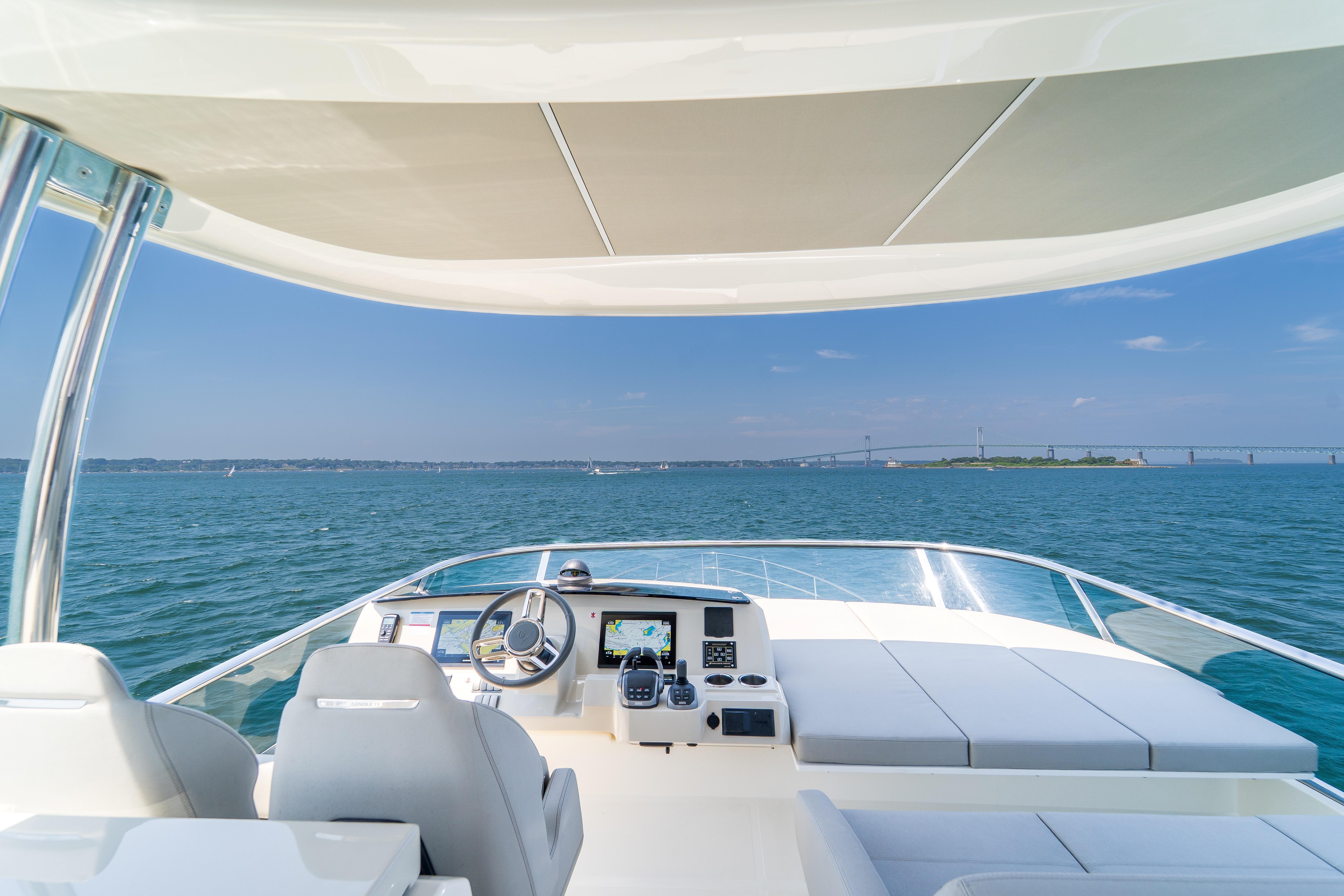 2023 Absolute 62 Fly yacht helm with ocean view and bridge in the distance.