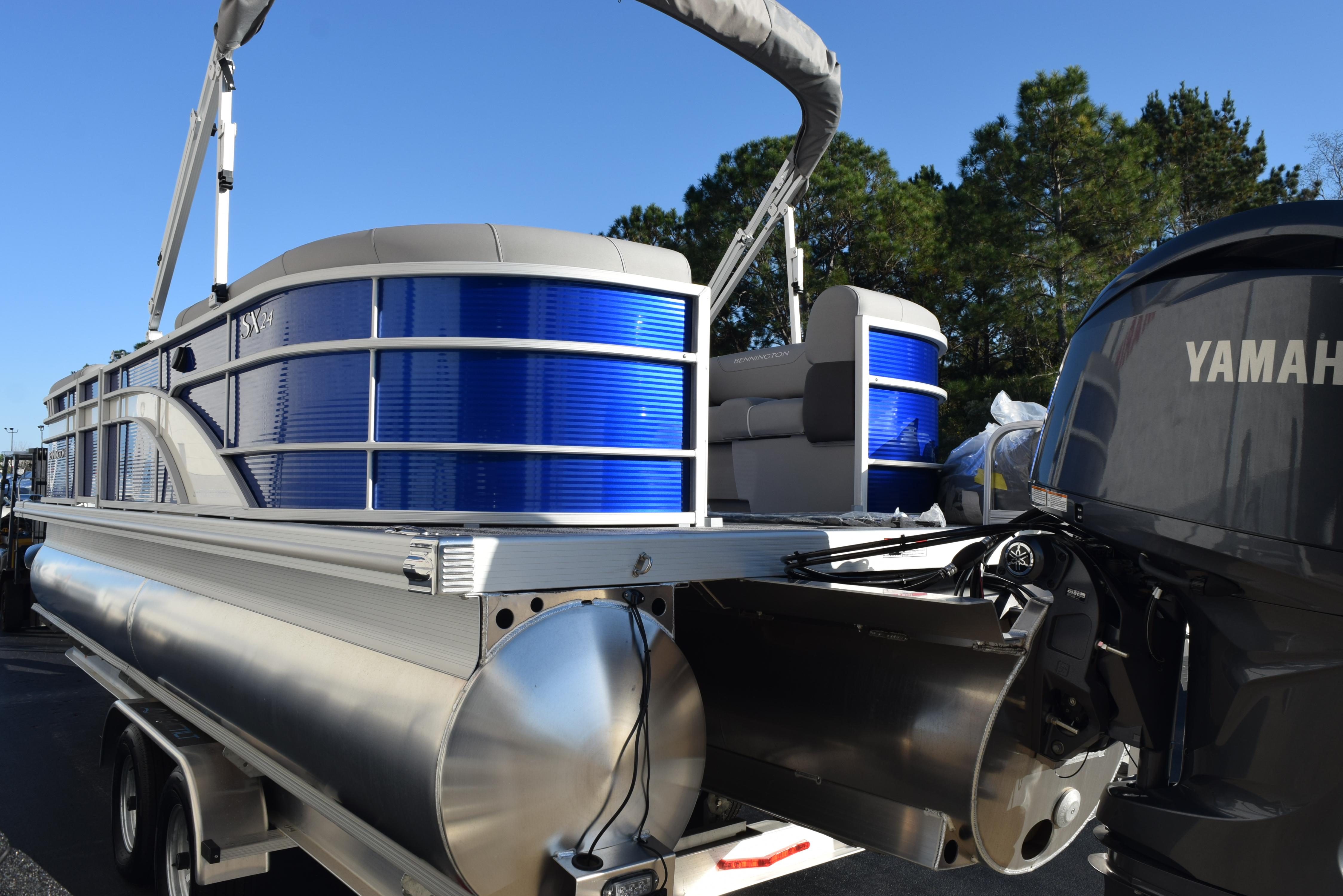 2025 Bennington SX 24 Quad Bench pontoon boat with Yamaha motor, parked outdoors.