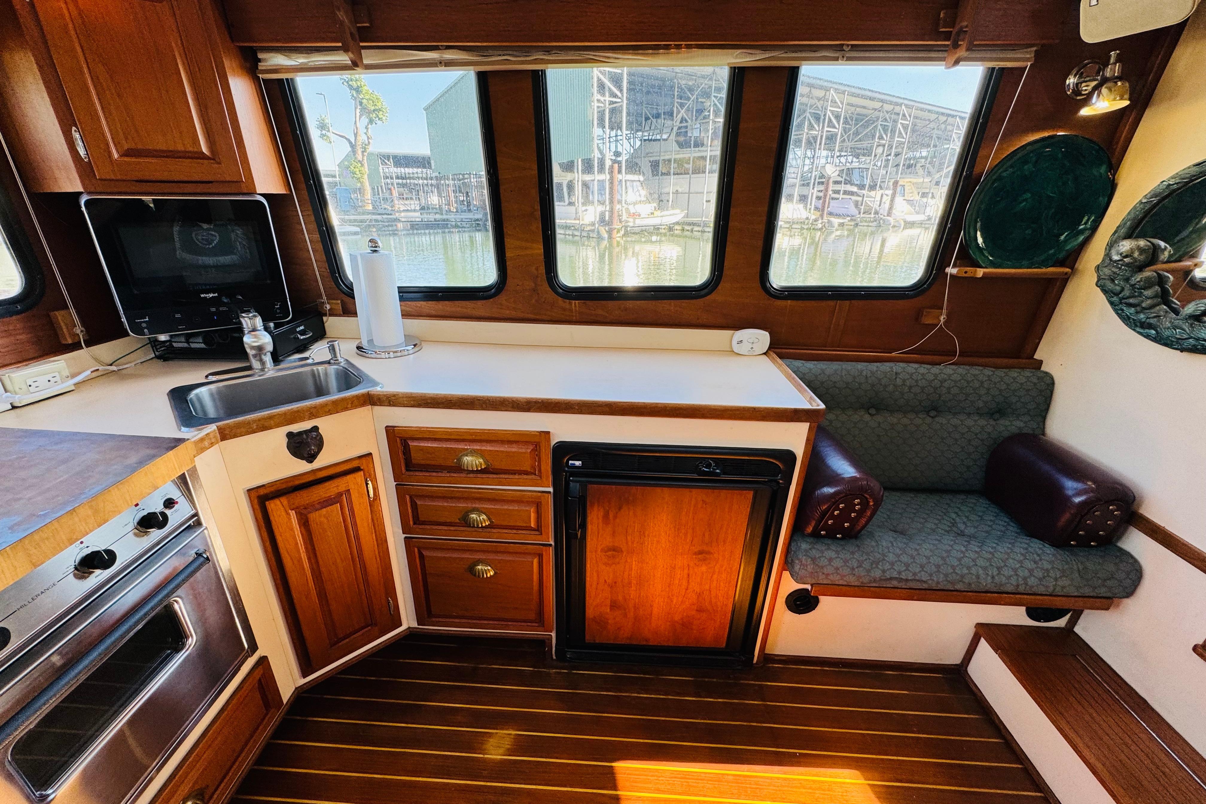 Interior of a 1996 Nordic Tug 32, featuring a cozy kitchen and seating area.