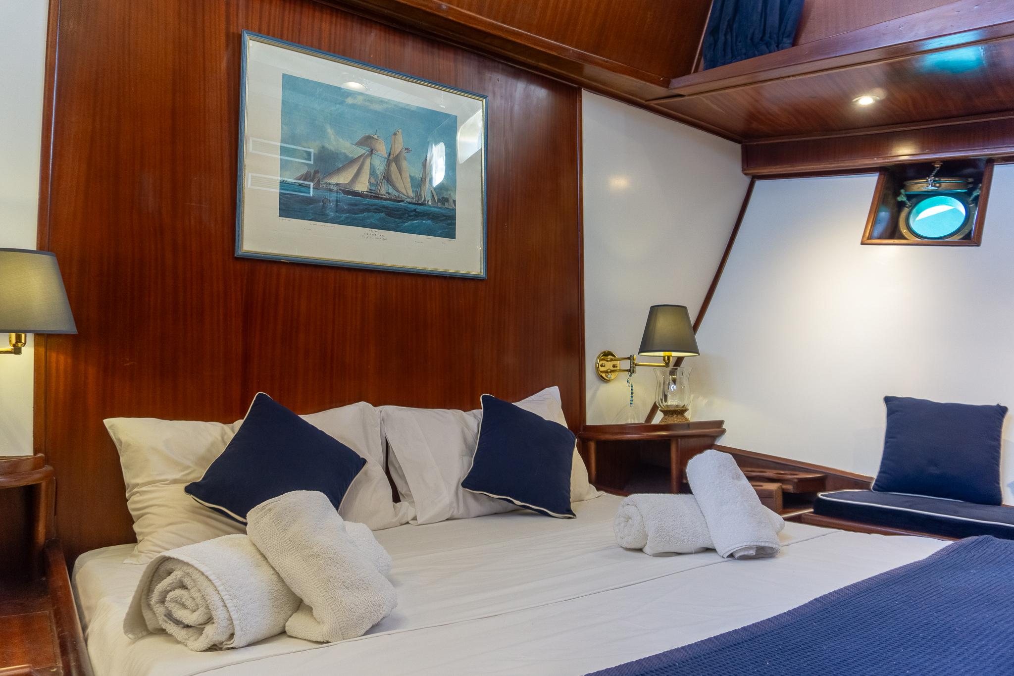 Luxurious cabin interior on 1969 Psarros Shipyard yacht, featuring cozy bed and nautical decor.
