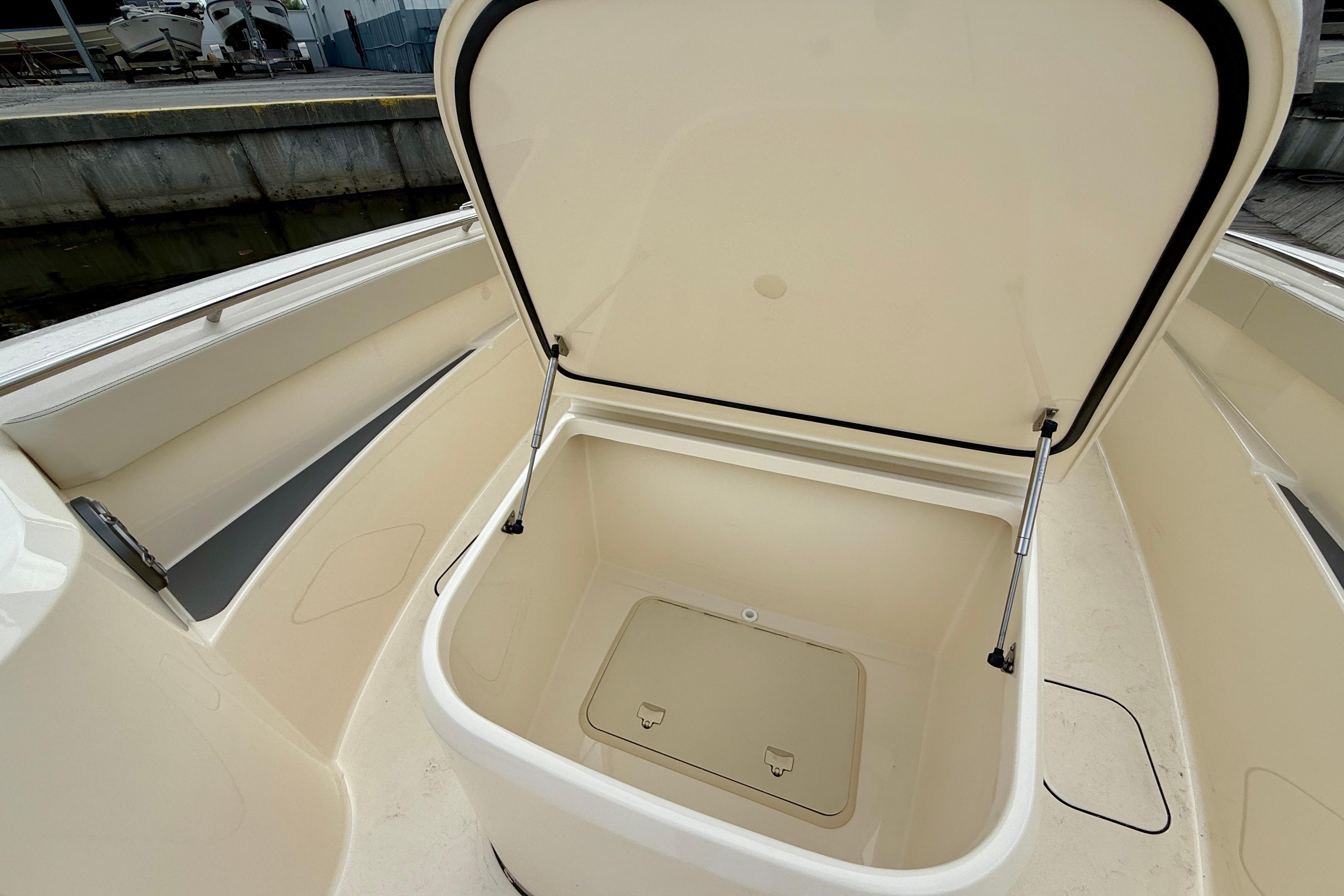 Open storage compartment on 2026 Scout 288 LXF boat, showcasing spacious interior design.